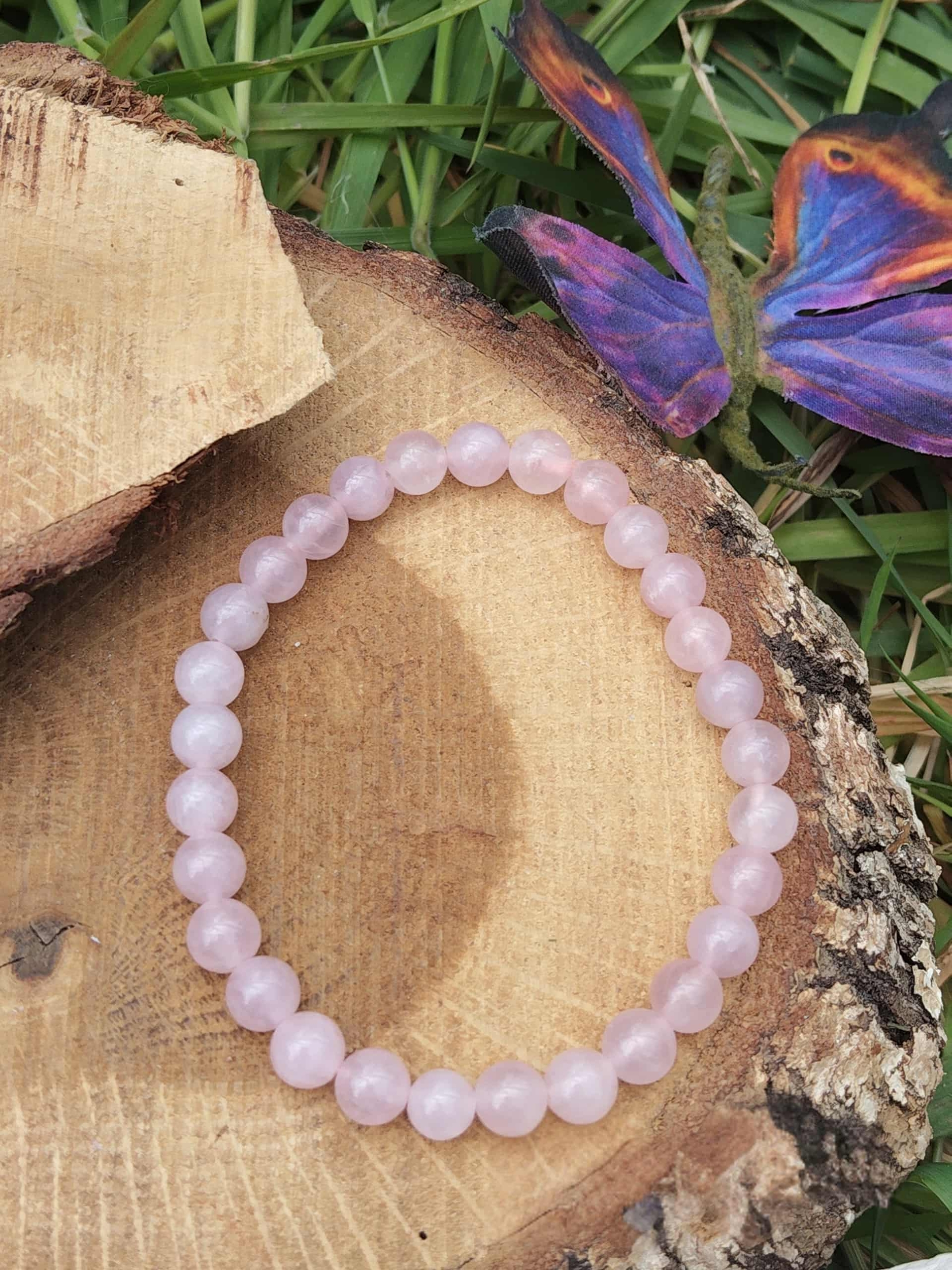 Bracelet quartz rose 6 mm sur rondin de bois avec herbes vertes et papillon coloré, douceur affective, réconfort émotionnel et paix du cœur