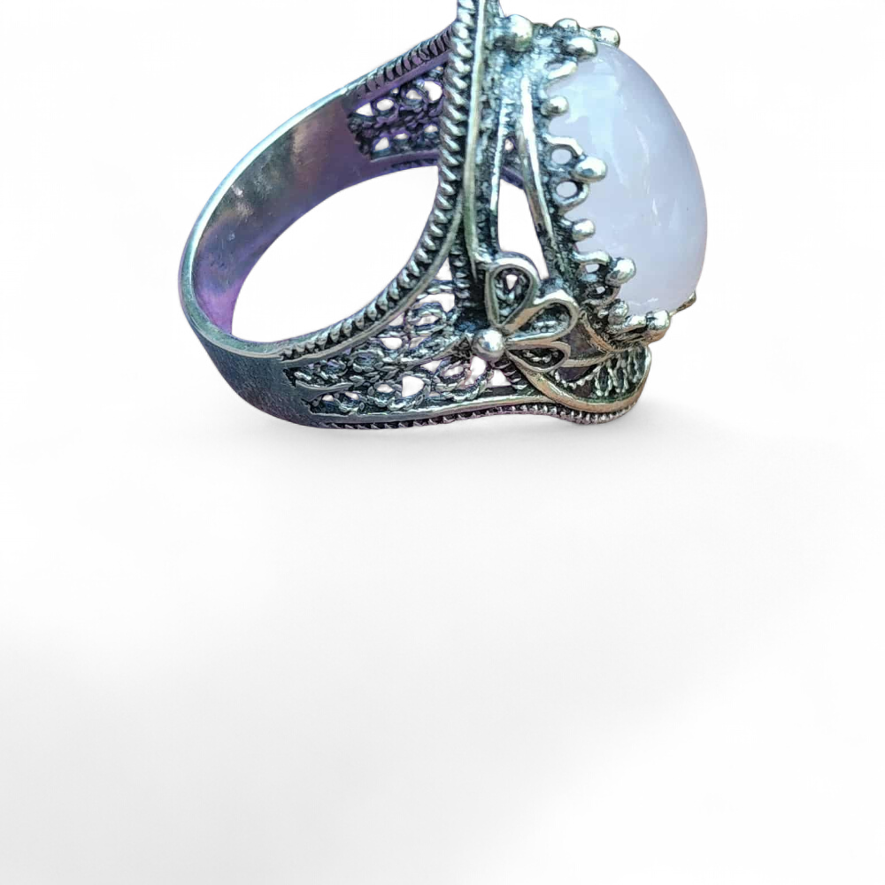 Bague filigranée argent 925 avec cabochon quartz rose, vue de profil sur fond blanc  douceur et ouverture du chakra du cœur.