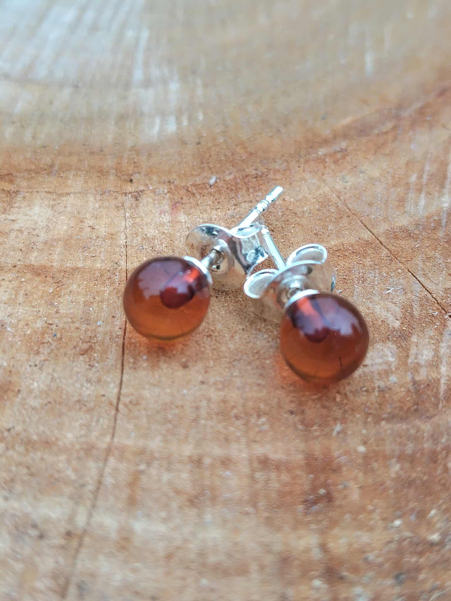 Puces ambre rondes argent 925 posées sur bois clair – confiance en soi, optimisme.