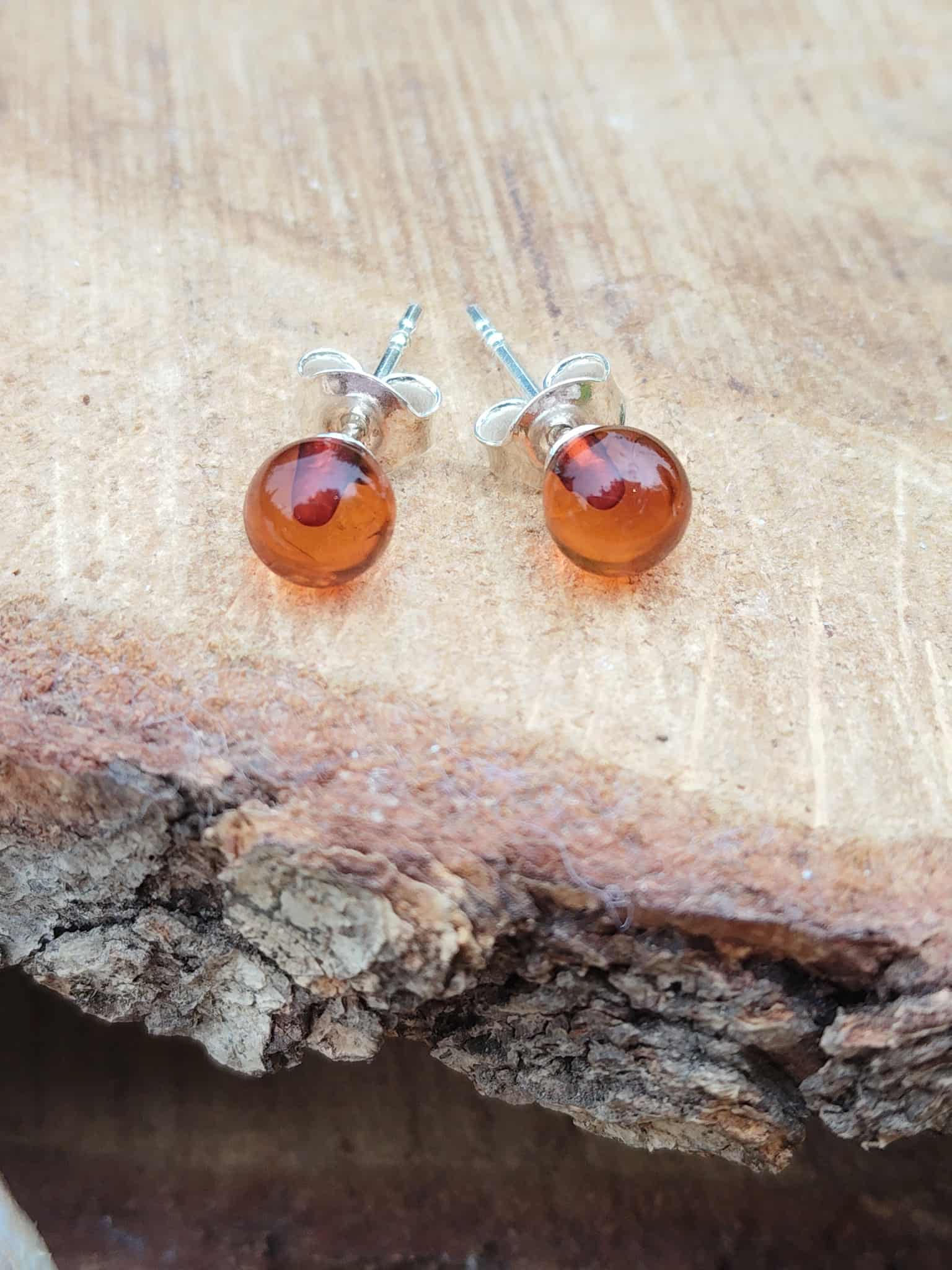 Ambre cognac en puces argent 925 sur tranche de bois – purification douce, équilibre émotionnel.