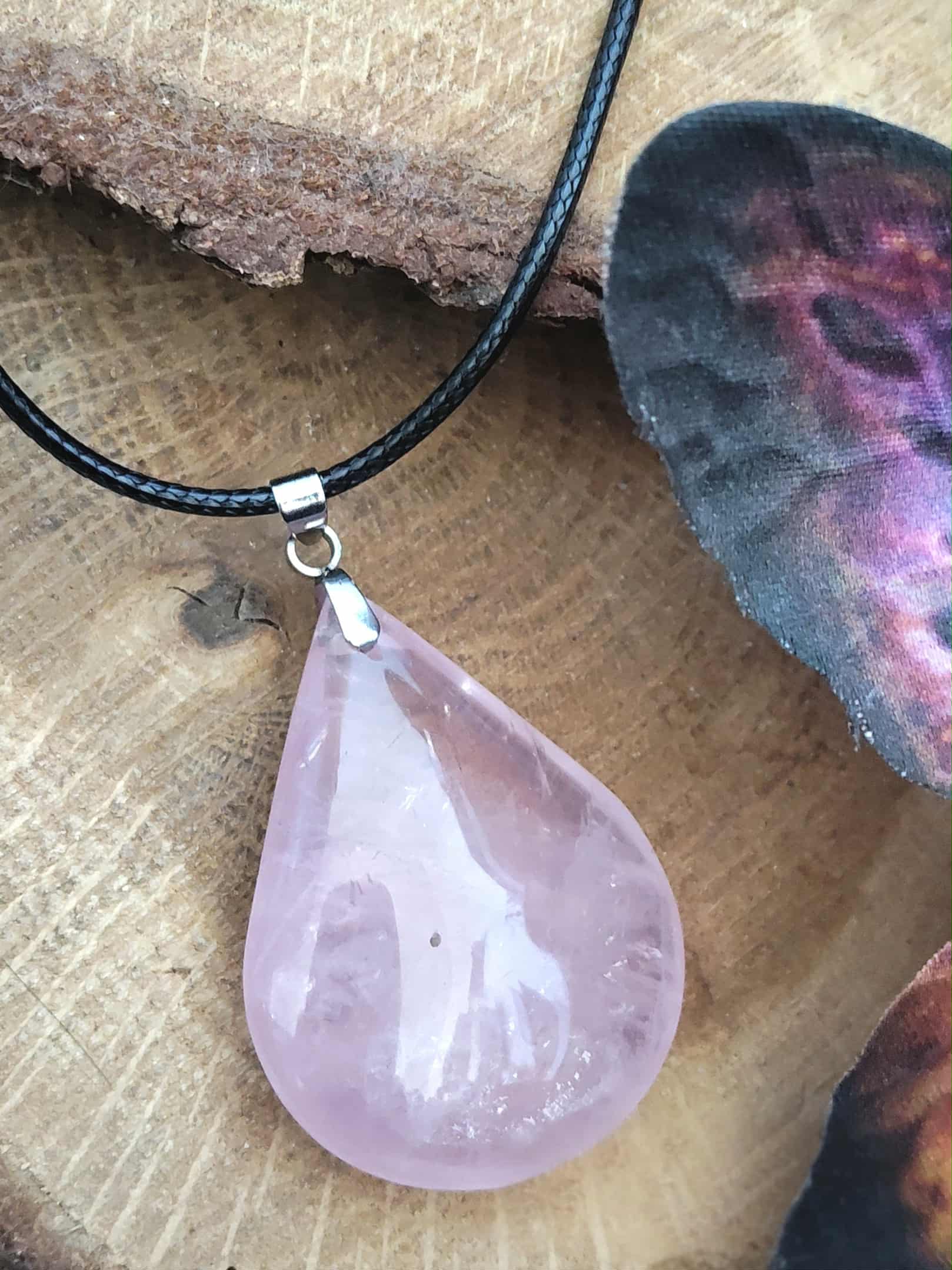 Pendentif quartz rose goutte sur cordon noir – amour, ouverture du cœur, apaisement émotionnel – décor bois