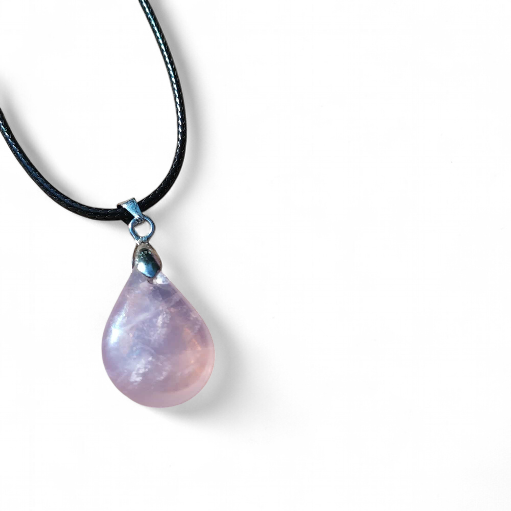 Pendentif quartz rose sur cordon noir en packshot fond blanc, collier en pierre naturelle évoquant le calme relationnel, l’apaisement et la présence à soi.