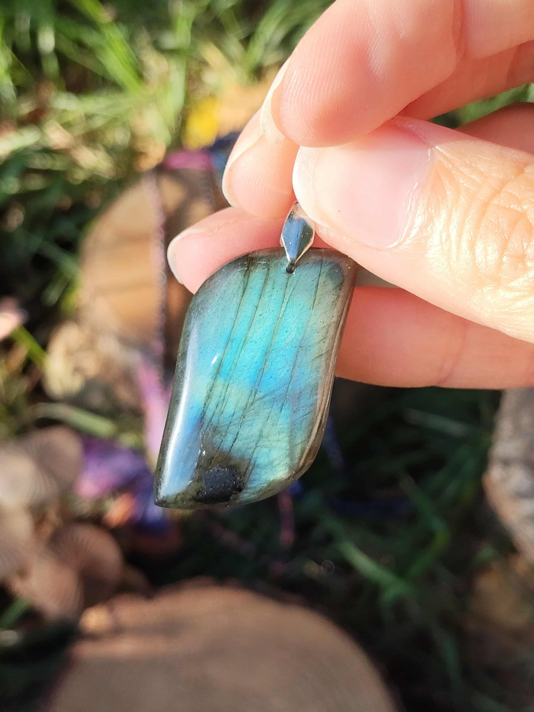 Pendentif labradorite verte en main, lumière naturelle — harmonie émotionnelle, troisième œil