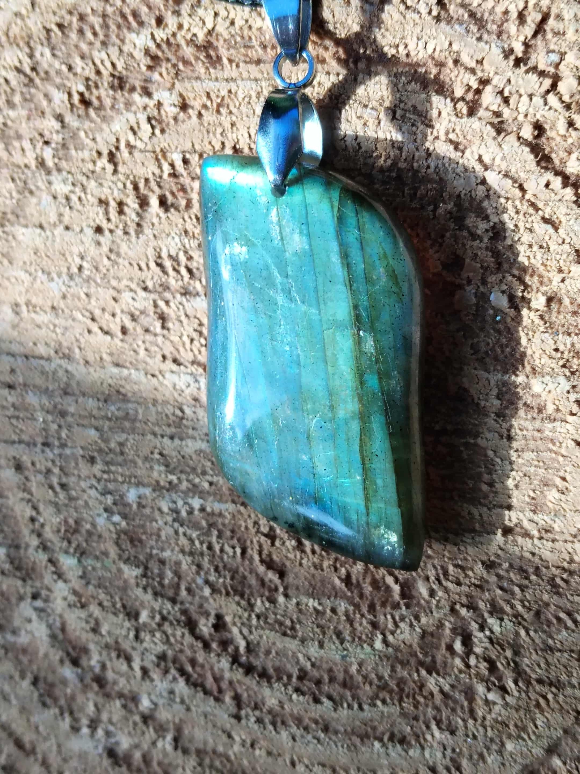 Pendentif labradorite verte sur fond zen texturé — protection énergétique, intuition