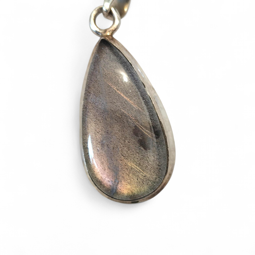 Pendentif goutte en labradorite violette serti en argent 925 sur fond blanc, reflets irisés subtils, bijou associé à l’intuition, au discernement et à la protection douce.