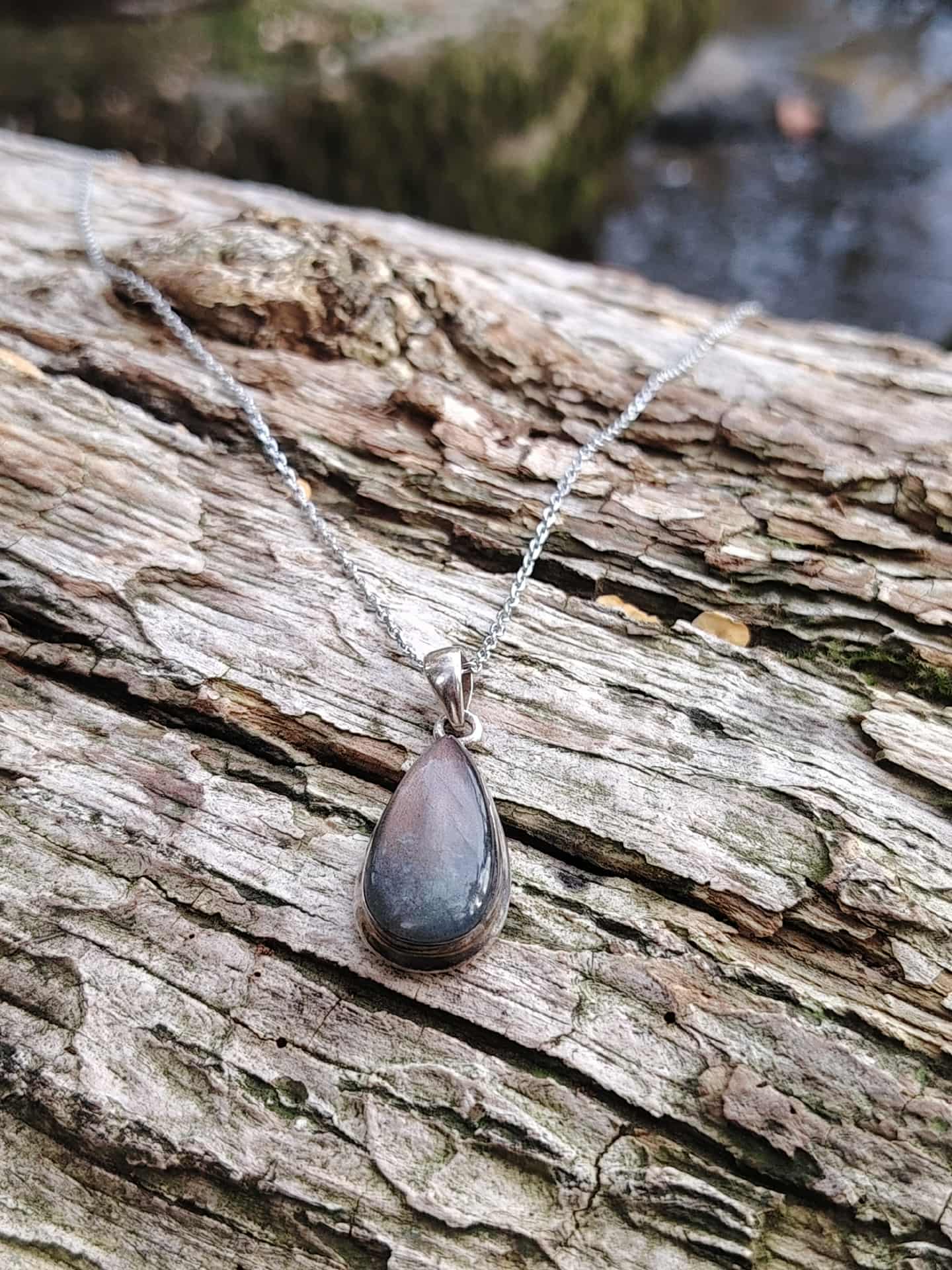 Pendentif labradorite violette en argent 925 posé sur écorce, bijou en pierre naturelle évoquant la vigilance intérieure, l’intuition et la stabilité émotionnelle.