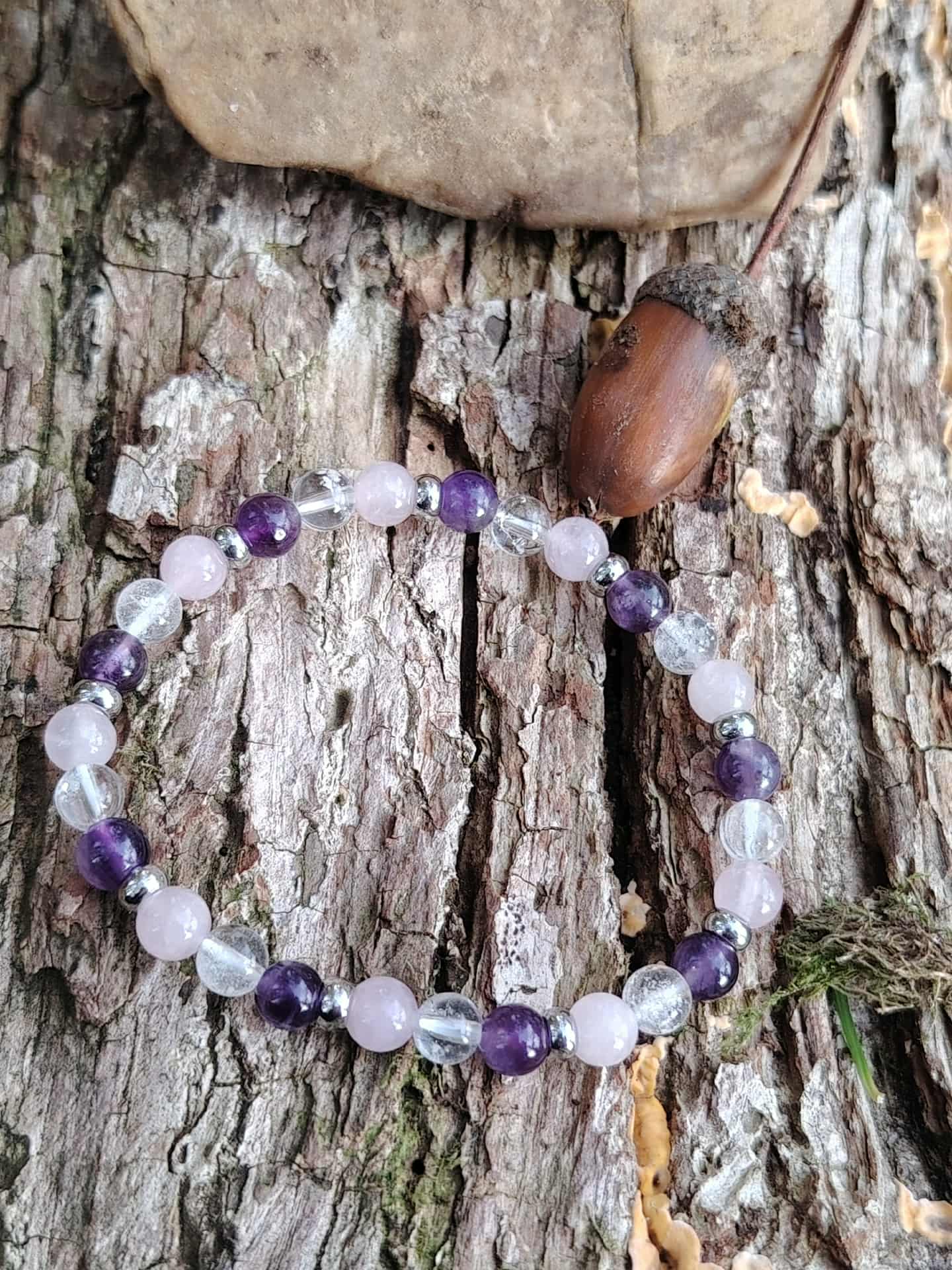 Bracelet trio améthyste, quartz rose et cristal de roche sur écorce en photo lifestyle, énergie douce, amour de soi et sérénité