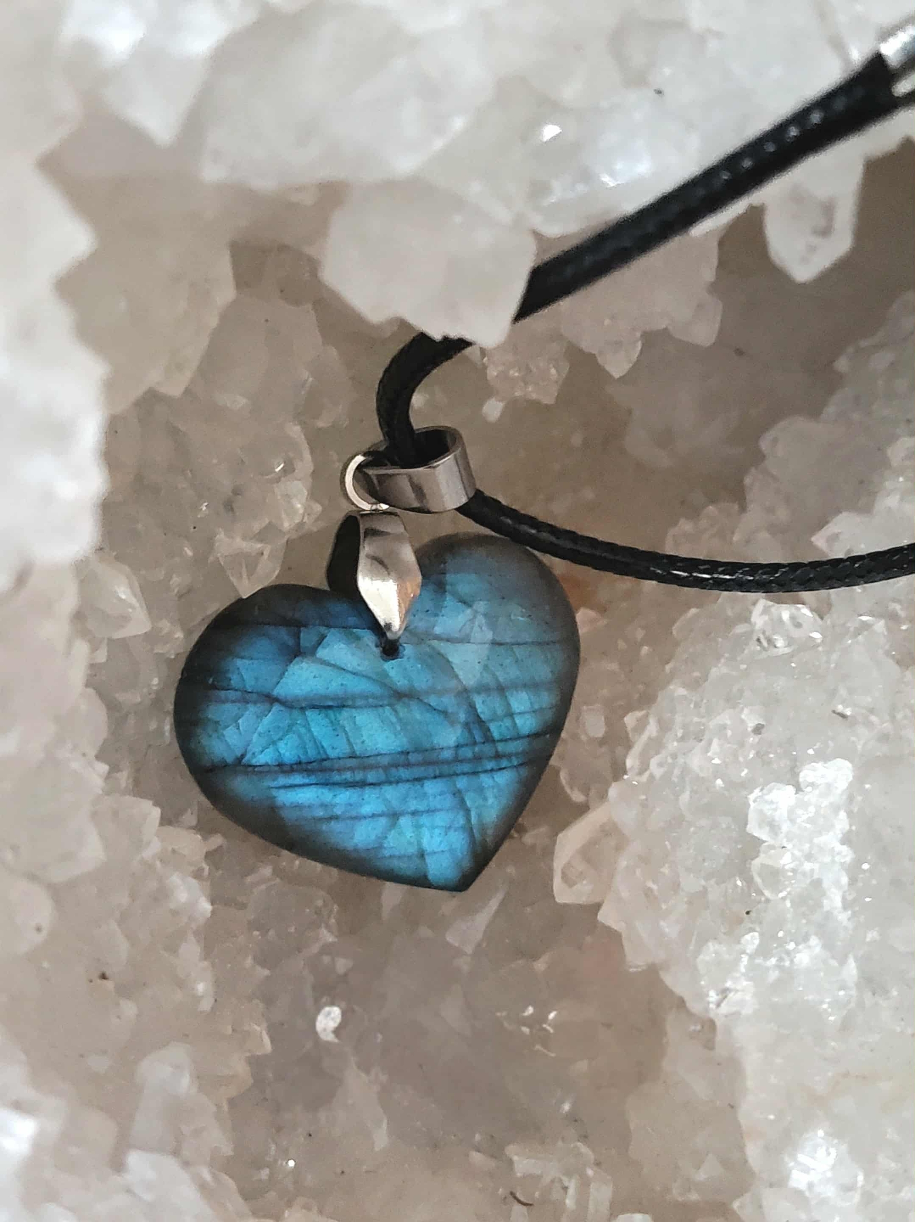 Pendentif cœur en labradorite aux reflets bleus sur décor minéral, bijou en pierre naturelle associé à l’apaisement, à la souplesse émotionnelle et à l’écoute de soi.