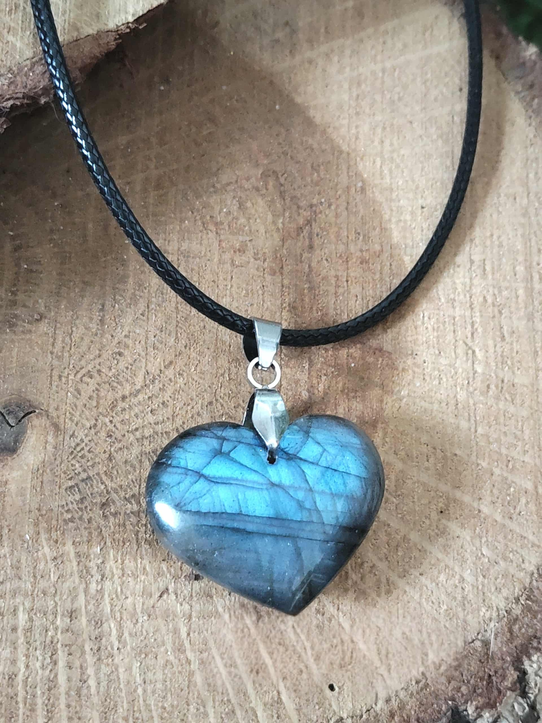 Pendentif cœur en pierre labradorite sur décor bois naturel, collier en pierre naturelle relié à l’harmonie intérieure, au recentrage et à la douceur émotionnelle.