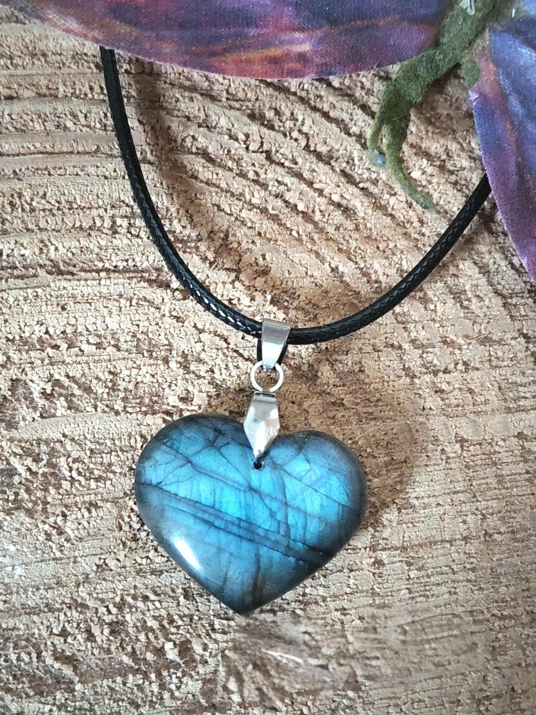 Pendentif cœur en labradorite à labradorescence bleue sur fond bois, bijou en pierre naturelle évoquant la lucidité, l’ancrage doux et la sérénité des pensées.