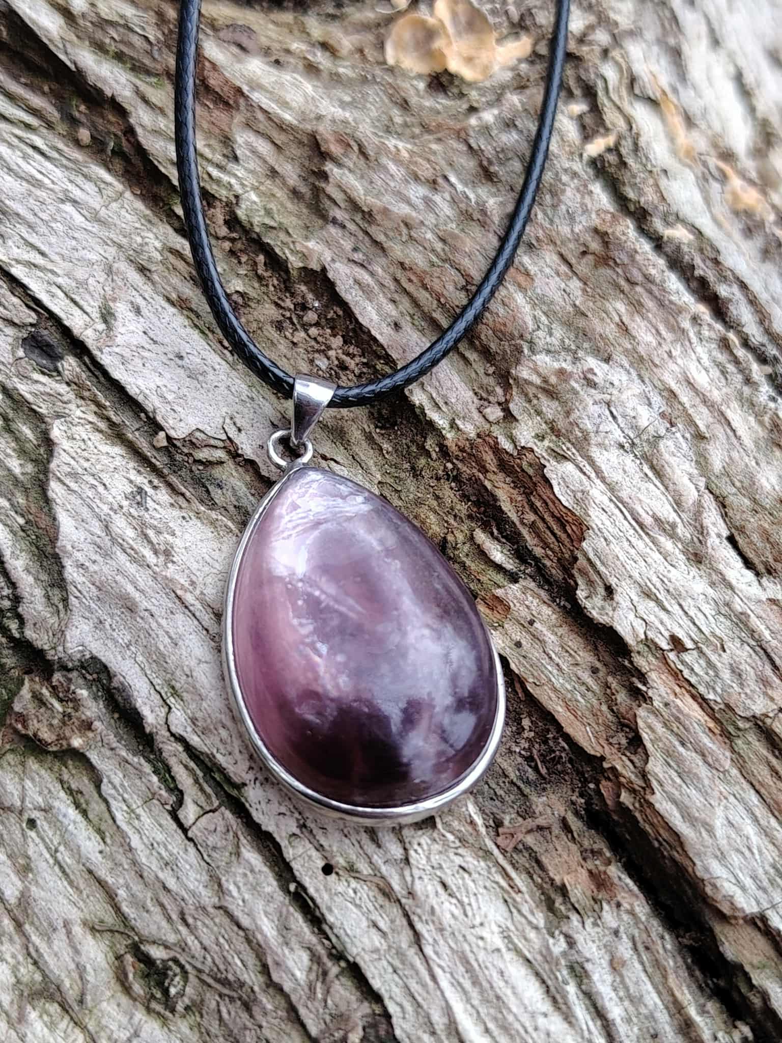 Pendentif lépidolite en argent 925 sur écorce de bois, bijou en pierre naturelle lié au calme des pensées, à la sensibilité équilibrée et à la stabilité intérieure.