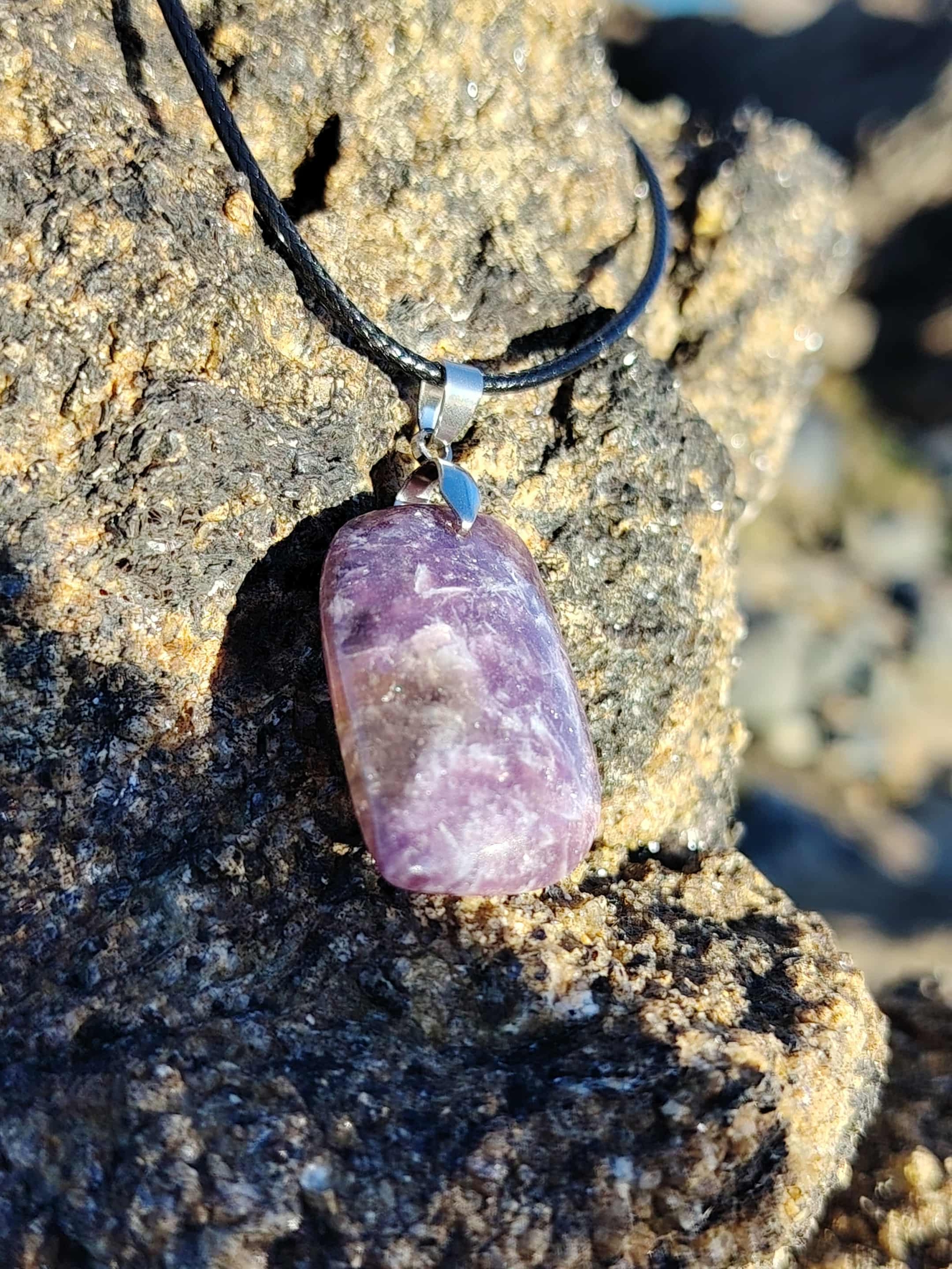Pendentif lépidolite rectangulaire sur rocher, bijou en pierre naturelle associé au calme intérieur, à la douceur émotionnelle et au recentrage.