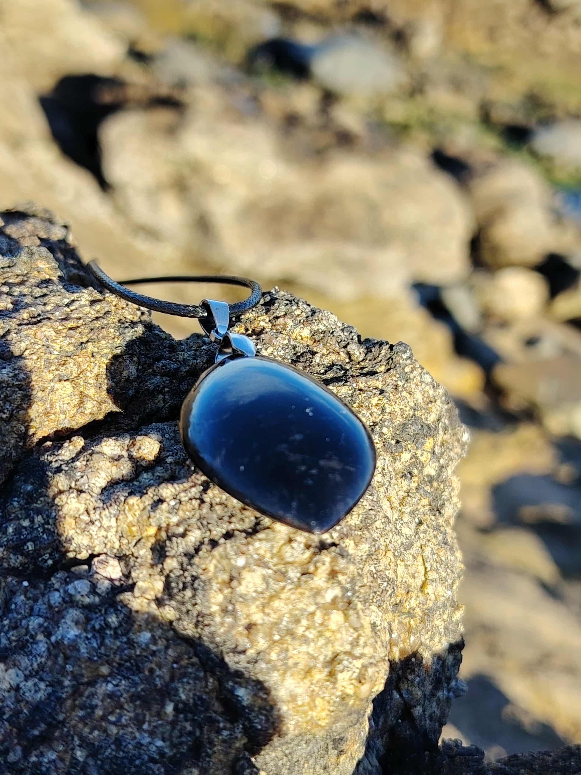 Collier en tourmaline noire sur roche, bijou en pierre naturelle associé à l’ancrage, à la protection subtile et à la sérénité intérieure.
