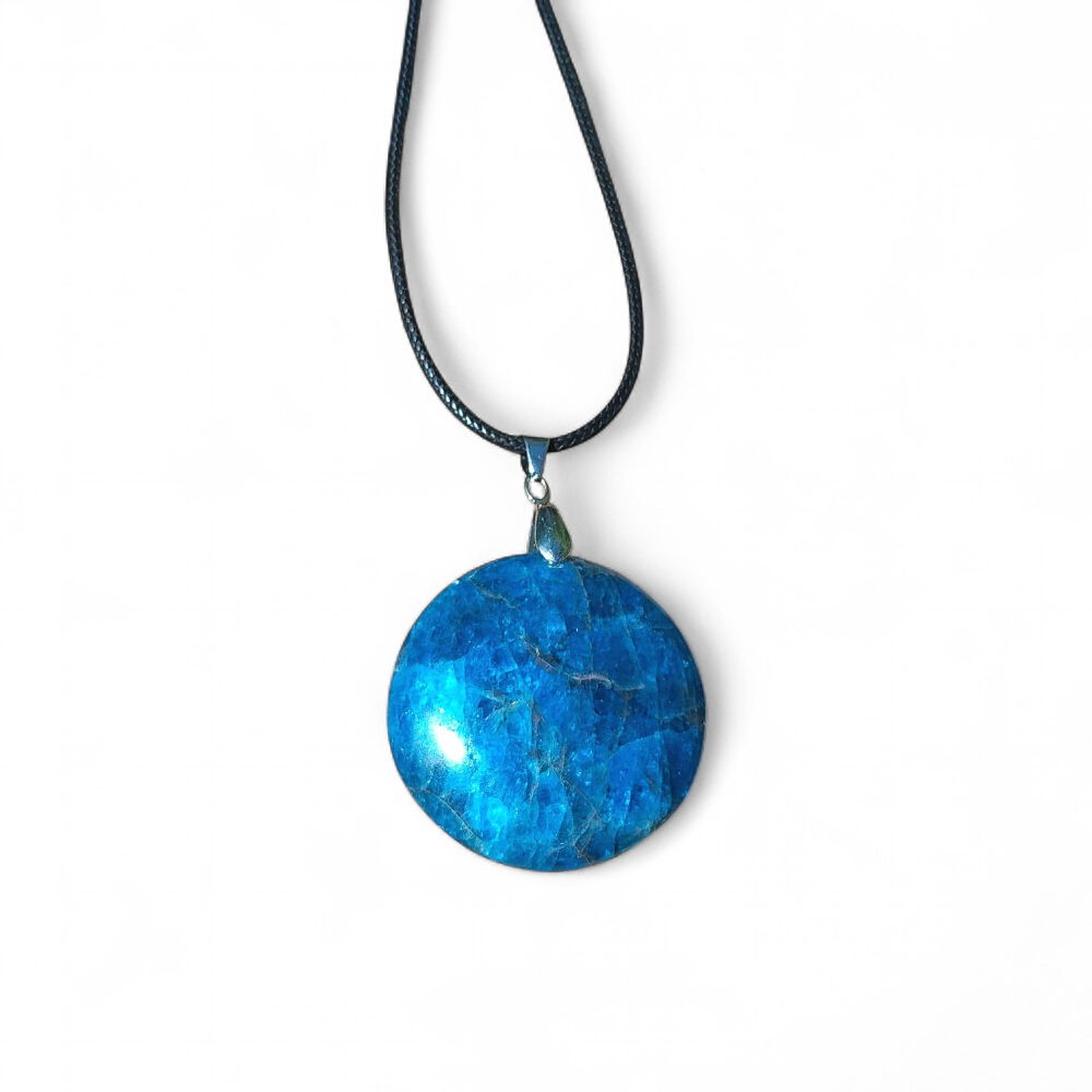 Pendentif apatite bleue naturelle sur fond blanc, pierre reliée au chakra gorge, à l’apaisement émotionnel et à l’expression sincère.