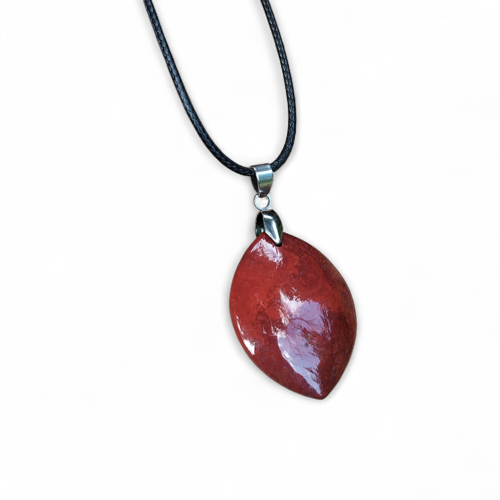 Pendentif jaspe rouge sur fond blanc, pierre naturelle liée à la vitalité, à l’ancrage et à la confiance corporelle.