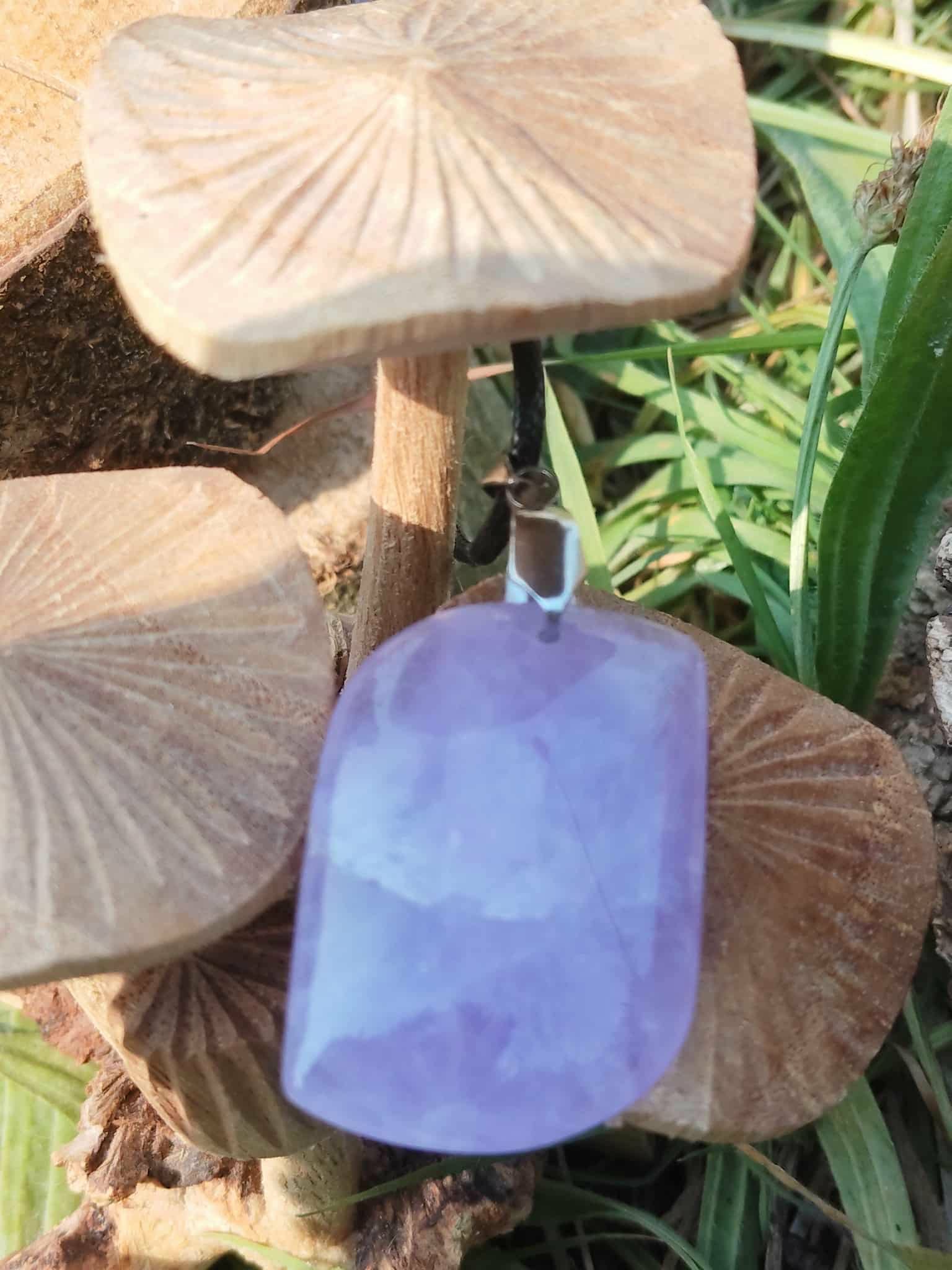 Pendentif améthyste violette sur champignons et herbe, connexion spirituelle et harmonie du ressenti