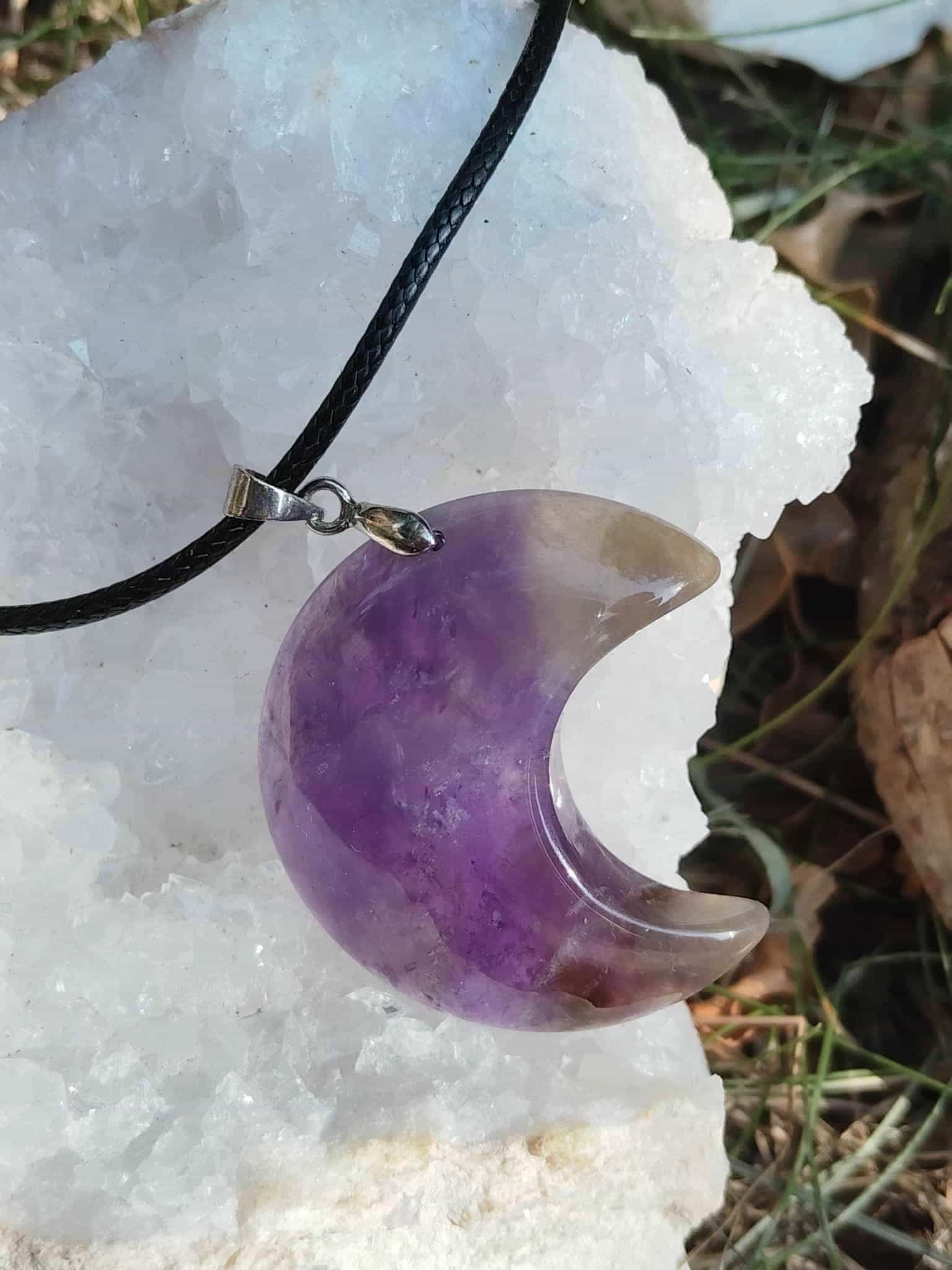 Pendentif lune en améthyste violette sur géode blanche et feuillage, bijou pierre naturelle associé à l’intuition, au calme intérieur et à la douceur émotionnelle.