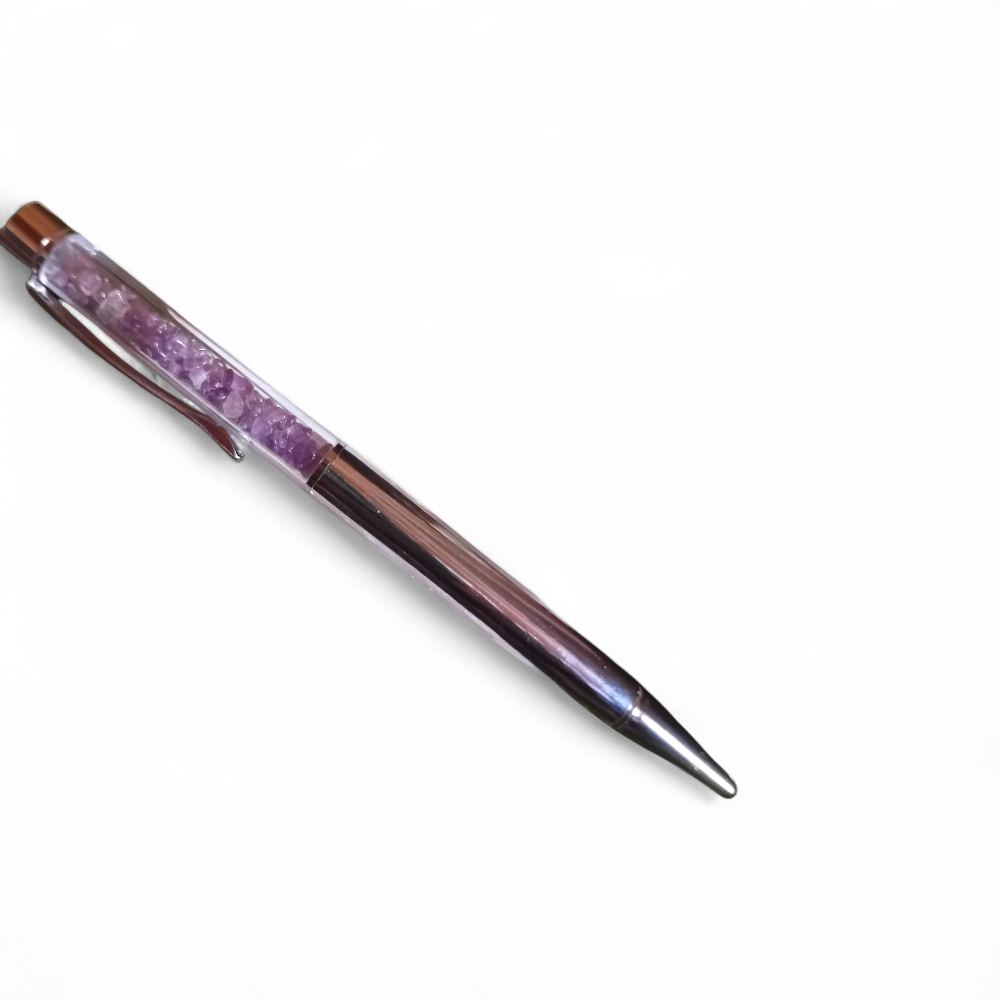 Stylo bille rempli d’éclats d’améthyste violette, accessoire d’écriture en pierres naturelles pour stimuler la créativité et le bien-être, présenté sur fond blanc – boutique ésotérique Magic Gaïa.