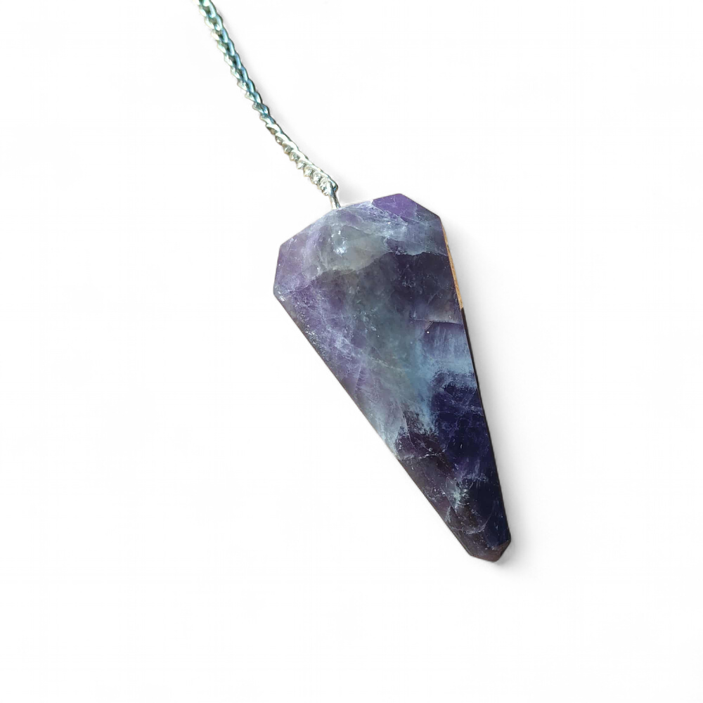 Pendule améthyste en pierre naturelle pour radiesthésie, intuition et spiritualité, posé sur chapeau de paille, outil énergétique pour apaisement mental et bien-être émotionnel.
