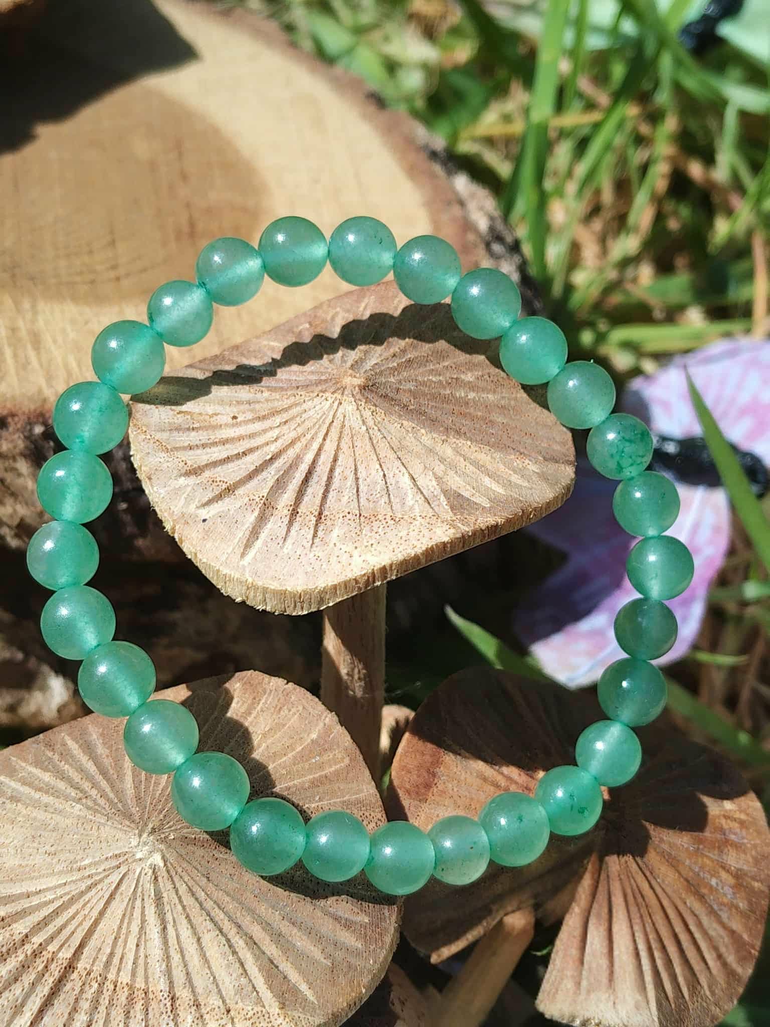 Bracelet aventurine verte 6 mm autour de champignons dans l’herbe, apaisement du mental, tendresse intérieure et énergie du cœur