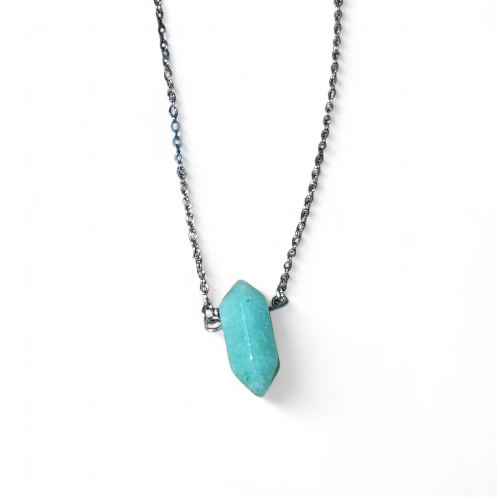 Collier minimaliste avec pendentif pointe aventurine verte sur cordon noir, présenté sur fond blanc, bijou en pierre naturelle relié au calme intérieur, au recentrage et à la sérénité émotionnelle.