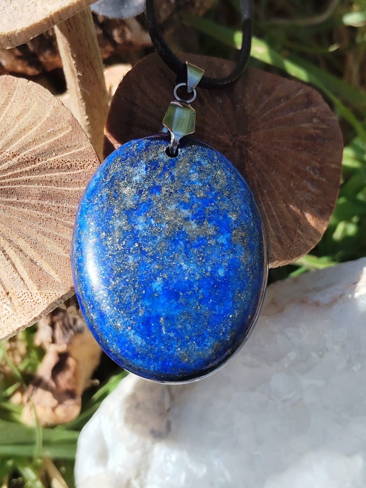 Pendentif en lapis lazuli bleu sur fond nature, bijou en pierre naturelle associé à l’expression personnelle, à la lucidité et à l’harmonie intérieure.