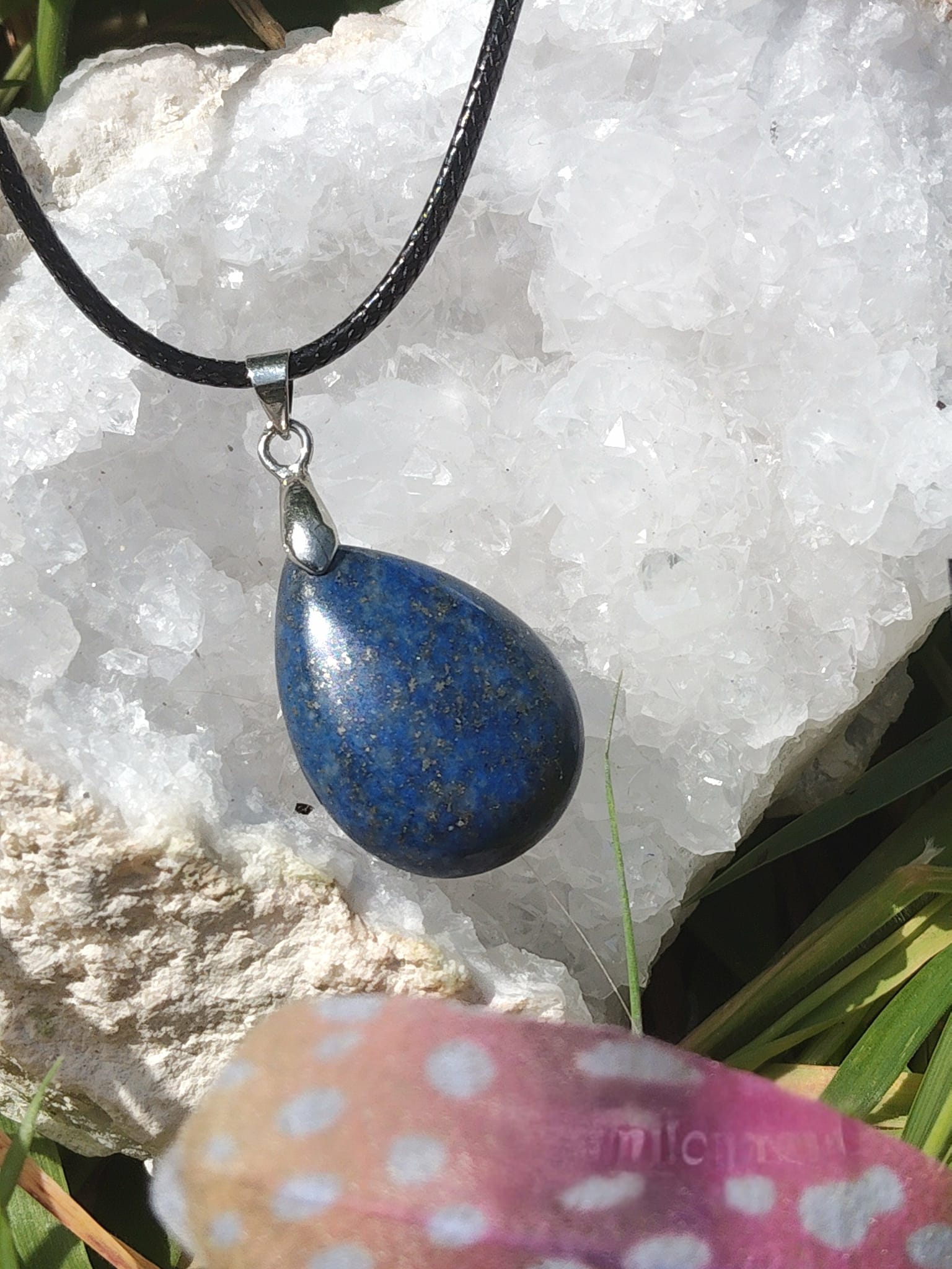 Pendentif goutte en lapis lazuli bleu sur géode blanche avec décor coloré, bijou en pierre naturelle évoquant la franchise, la vision intérieure et la paix émotionnelle.
