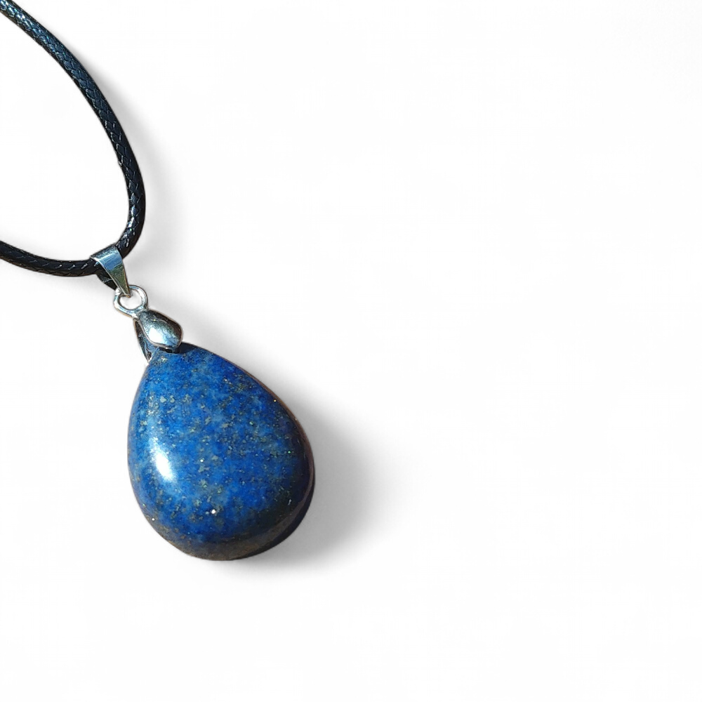 Pendentif goutte en lapis lazuli bleu sur fond blanc, bijou en pierre naturelle relié à l’expression sincère, au discernement et à l’harmonie émotionnelle.