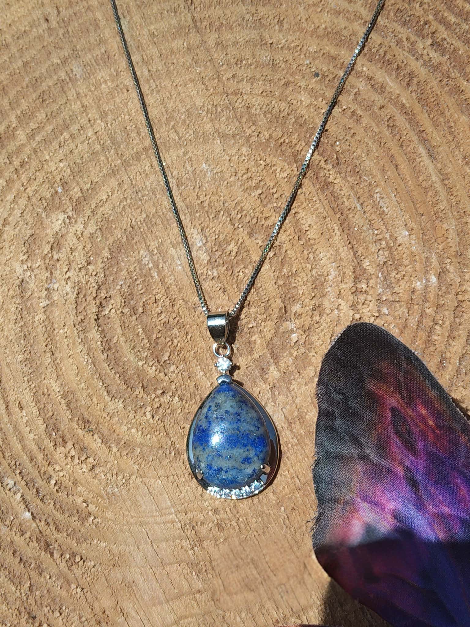 Bijou goutte en lapis lazuli sur décor nature, collier pierre naturelle associé à la sensibilité, à la créativité et à la paix émotionnelle.