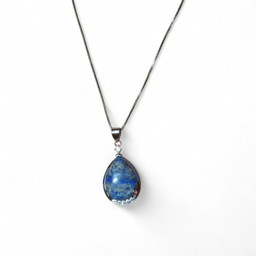 Pendentif goutte en lapis lazuli sur fond blanc, collier en pierre naturelle relié à l’expression sincère, à l’inspiration et à l’équilibre émotionnel.