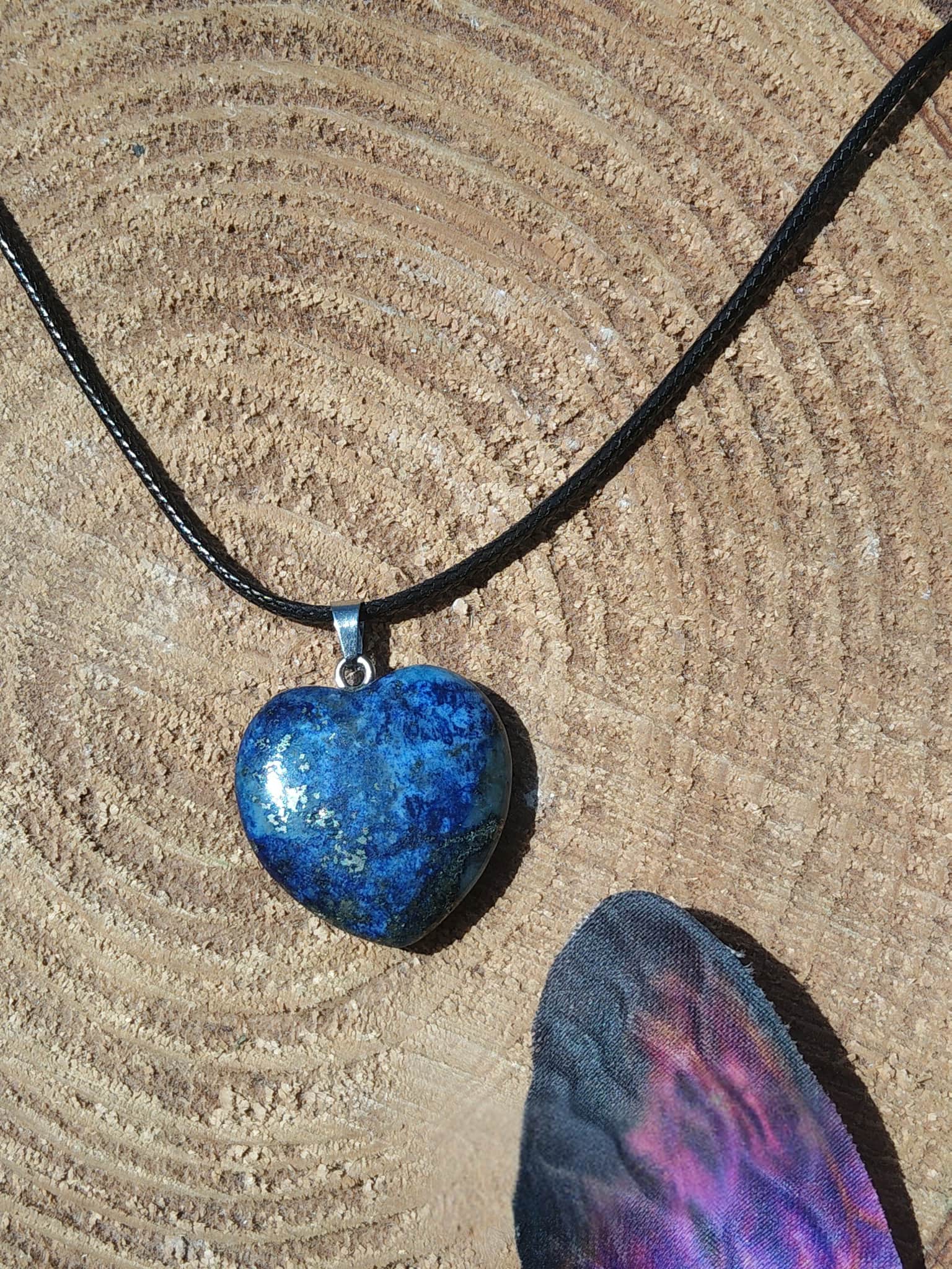 Pendentif cœur en lapis lazuli bleu sur rondin de bois avec aile violette, collier pierre naturelle relié à la franchise, au recentrage et à la tranquillité intérieure.