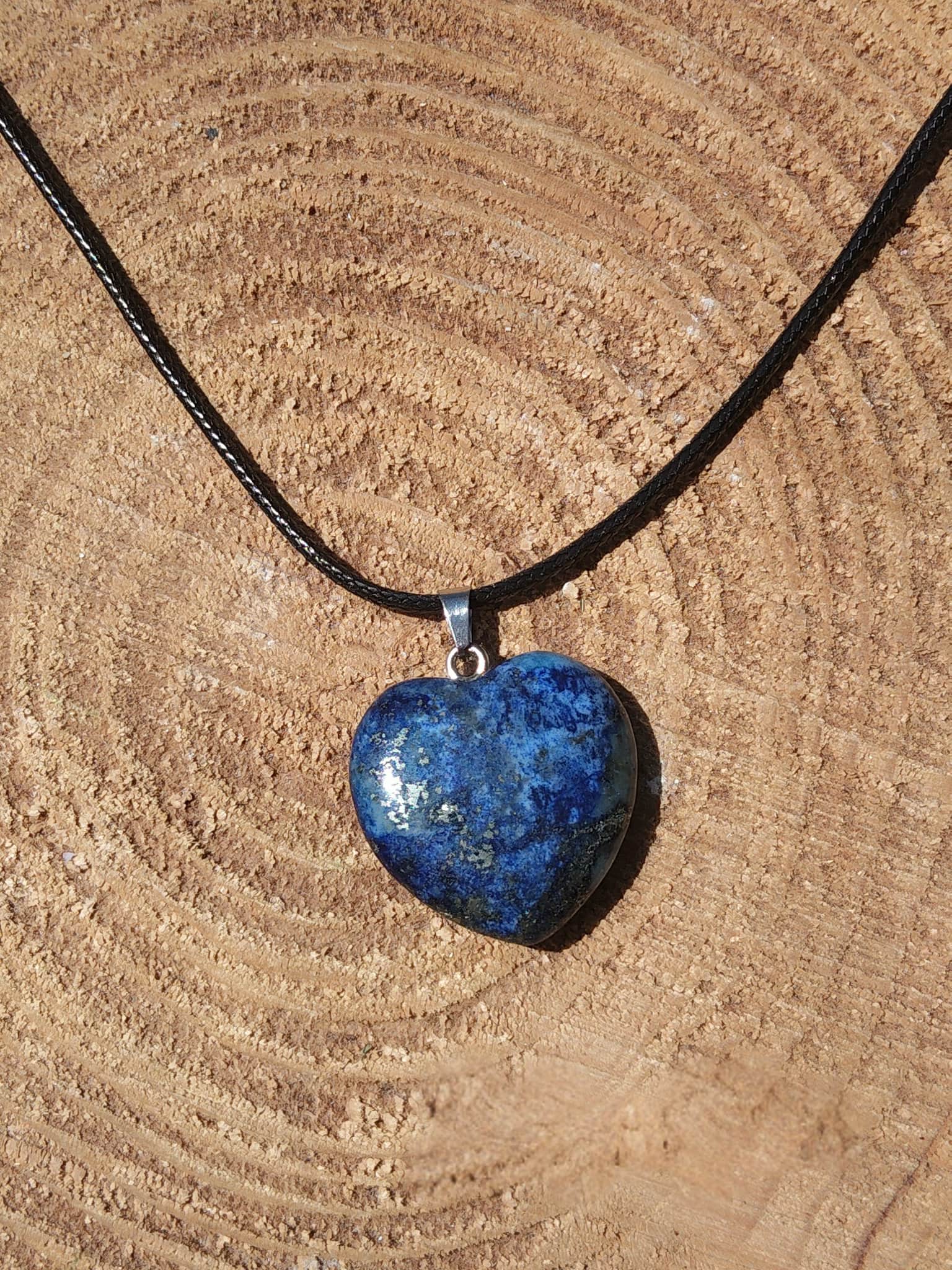 Pendentif cœur en lapis lazuli bleu sur rondin de bois, bijou pierre naturelle évoquant l’assurance, l’authenticité et le calme du mental.