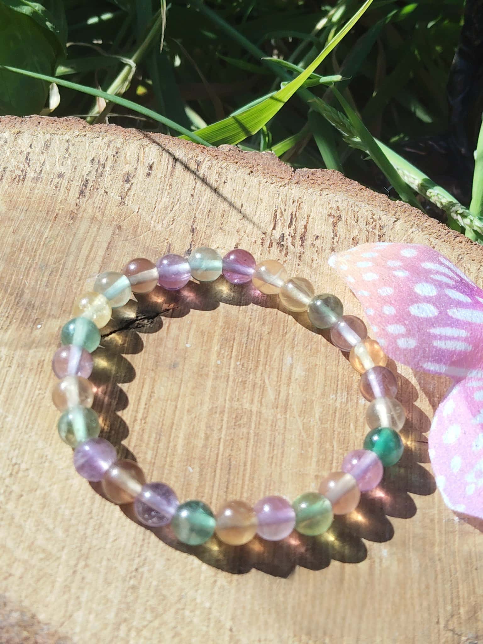 Bracelet fluorite multicolore en extérieur sur tranche de bois, bracelet en perles naturelles, harmonisation intérieure et lucidité