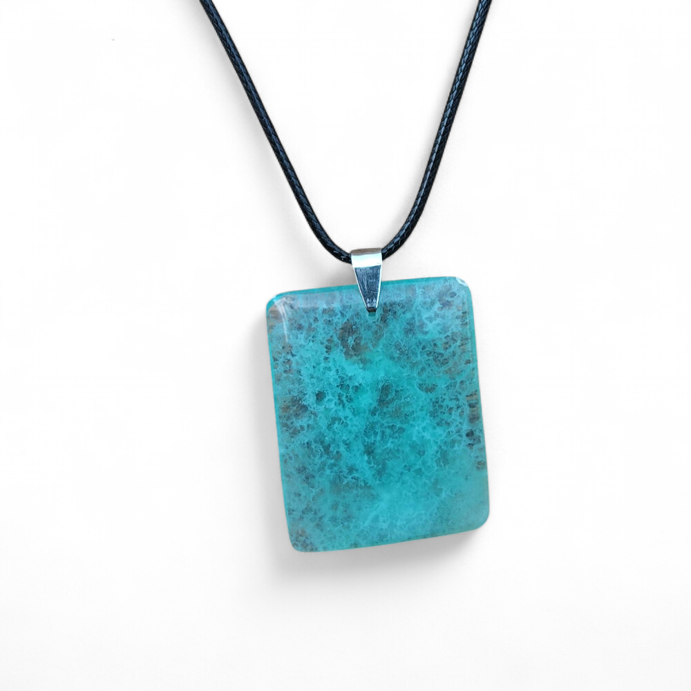 Collier en fluorite verte rectangulaire sur cordon noir, pierre vert d’eau mise en valeur sur fond clair, bijou naturel relié à la souplesse émotionnelle, à la clarté d’esprit et au calme.