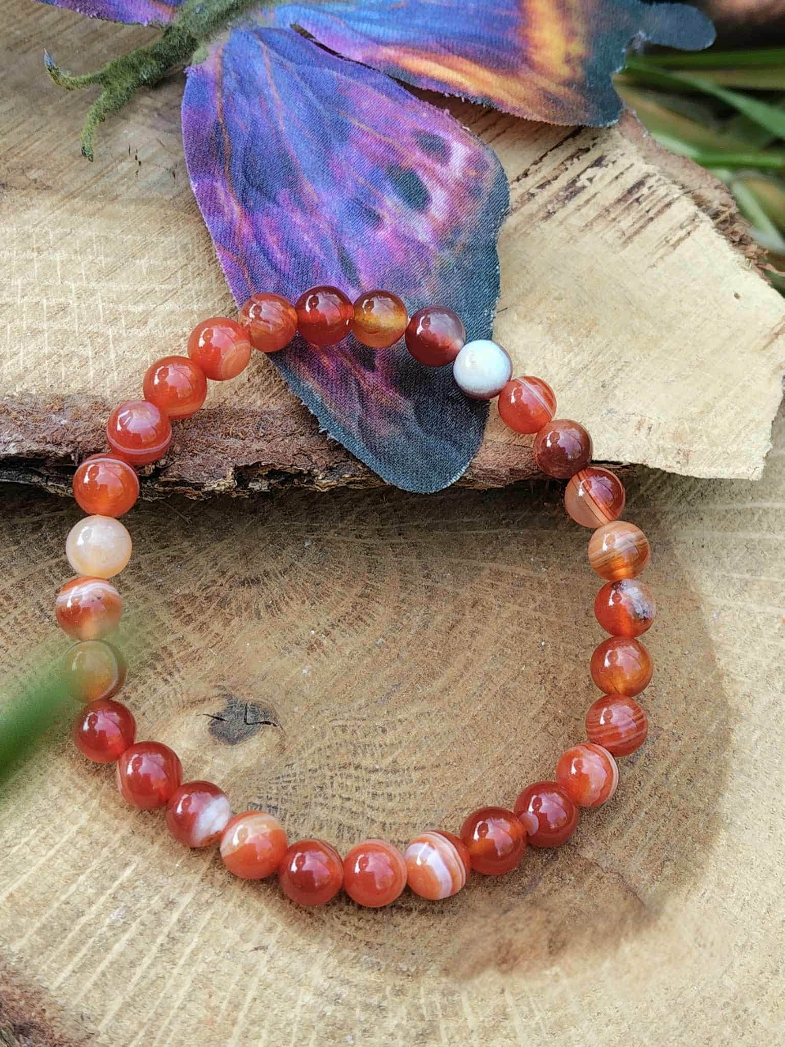 Bracelet cornaline sur support bois avec décor féerique, pierre naturelle orange pour courage, présence affirmée et énergie constructive