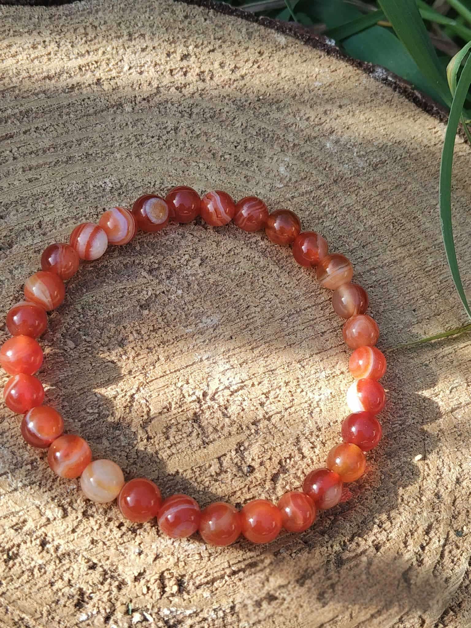 Bracelet cornaline posé sur bois, bijou en pierre orange pour focus mental, tonus intérieur et stabilité émotionnelle