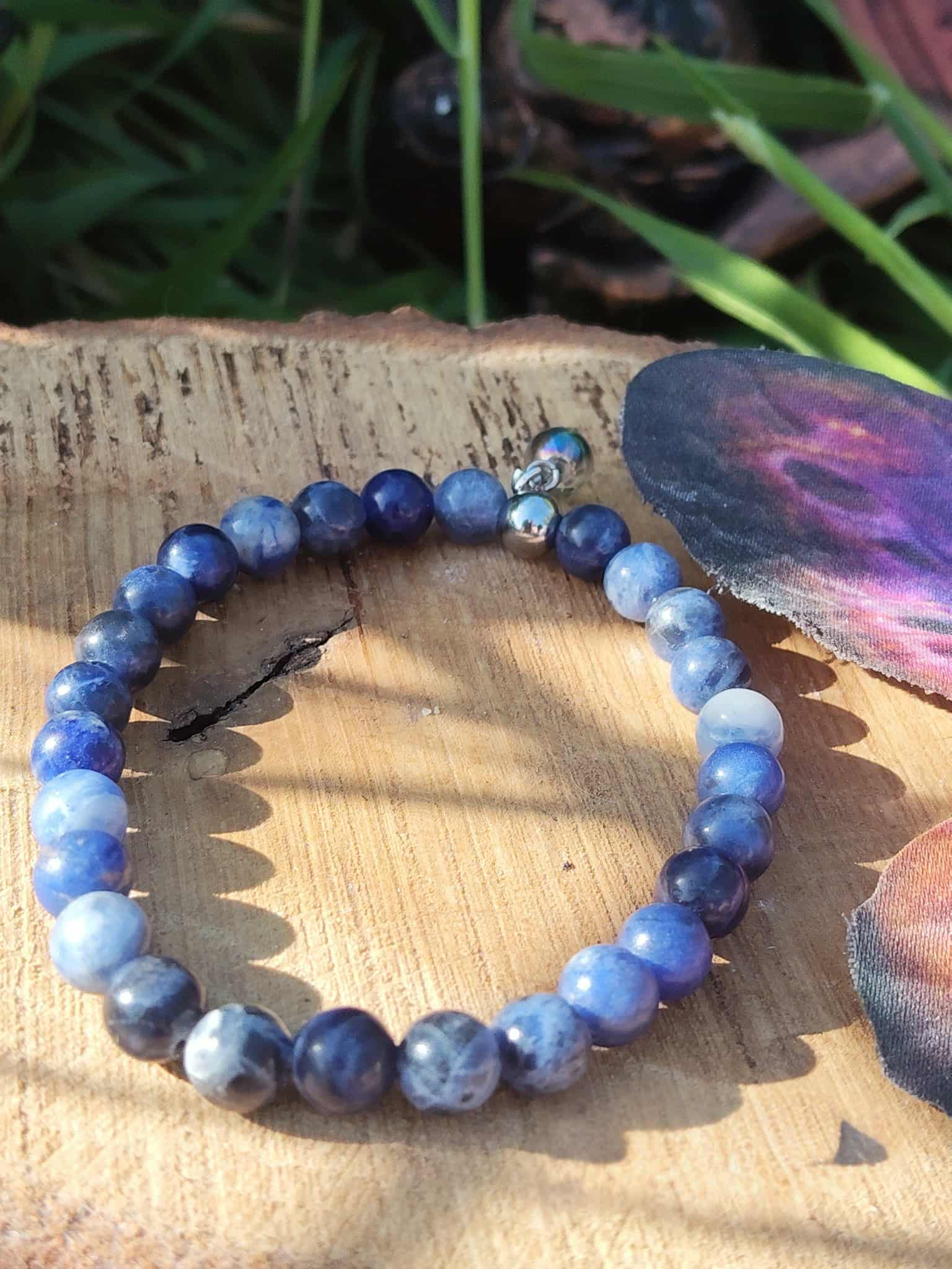 Bracelet sodalite 6 mm bleu intense et bleu ciel sur fond blanc, sérénité émotionnelle, réflexion claire et confiance dans l’expression