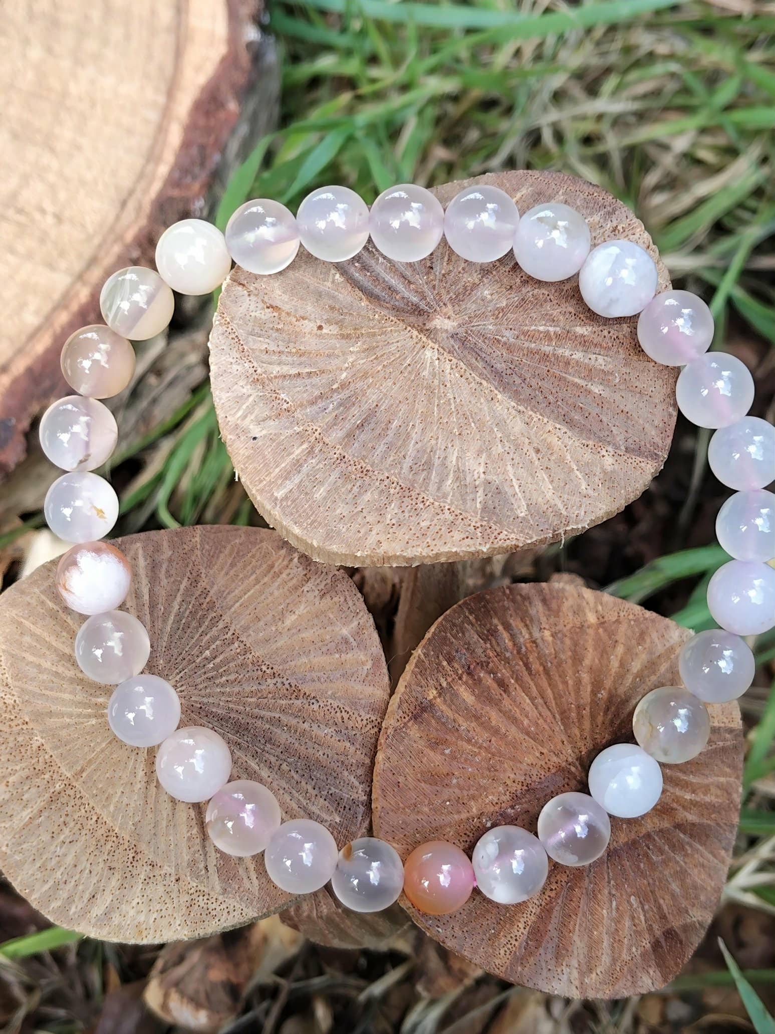 Bracelet agate fleur de cerisier mis en scène sur feuilles au sol, bijou lithothérapie aux accents floraux pour cocooning et apaisement