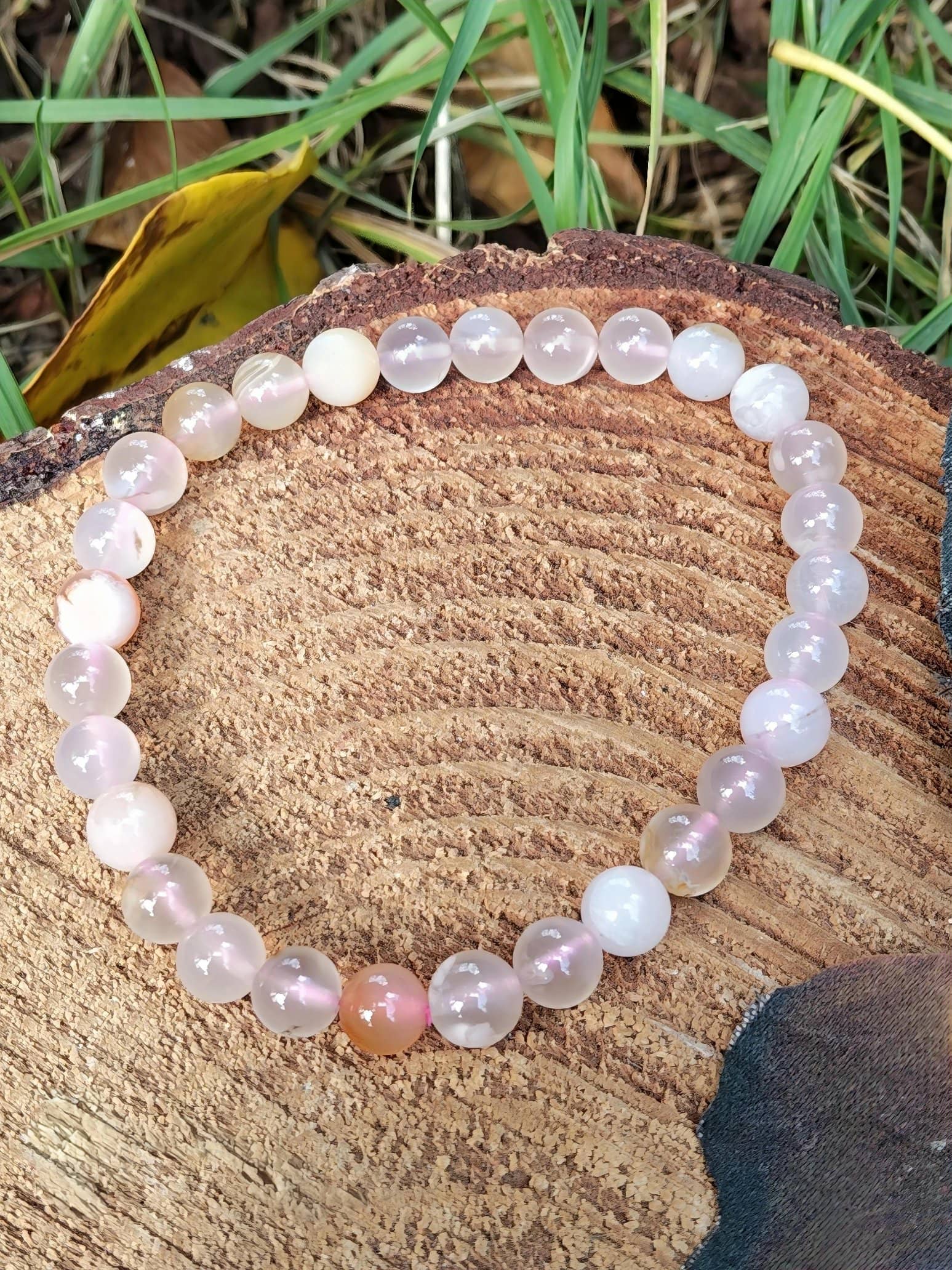 Bracelet agate fleur de cerisier sur rondin de bois avec herbe, bijou en pierre naturelle pour souplesse émotionnelle et paix intérieure