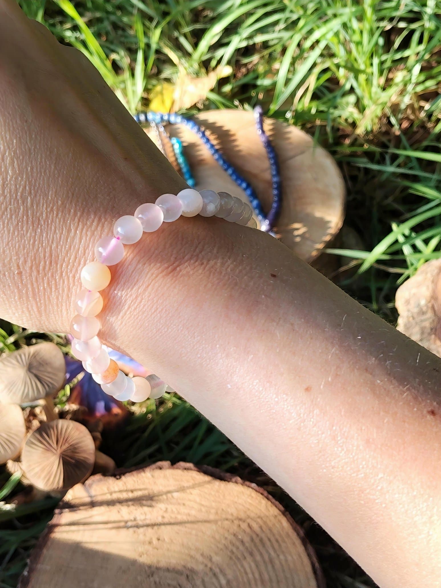 Bracelet agate fleur de cerisier porté au poignet en extérieur, perles rosées naturelles pour sérénité émotionnelle et réconfort