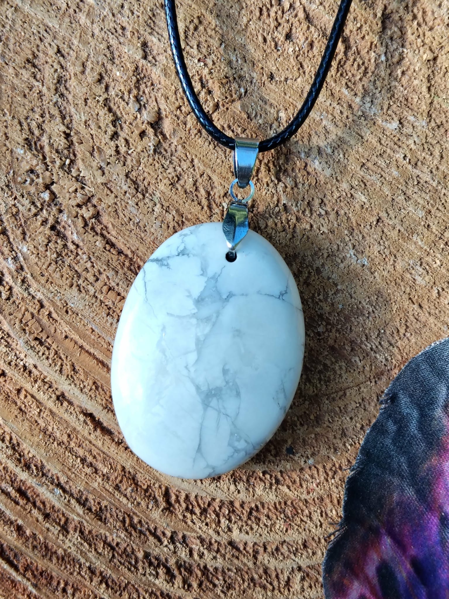 Pendentif howlite blanche veinée posé sur bois, patience, apaisement intérieur et respiration émotionnelle plus douce