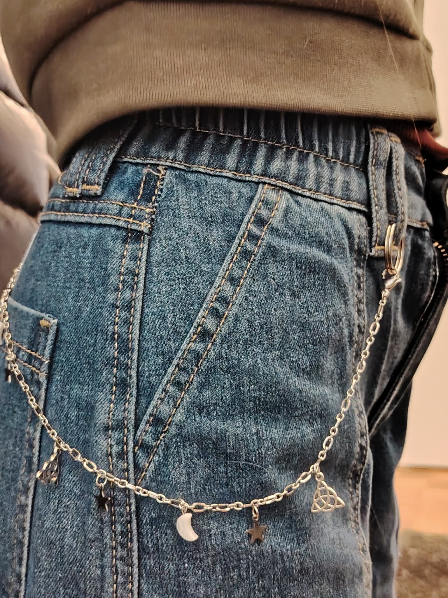 Chaîne de pantalon personnalisable portée sur jean bleu, avec breloques lune et charms, accessoire mode canon Magic Gaïa