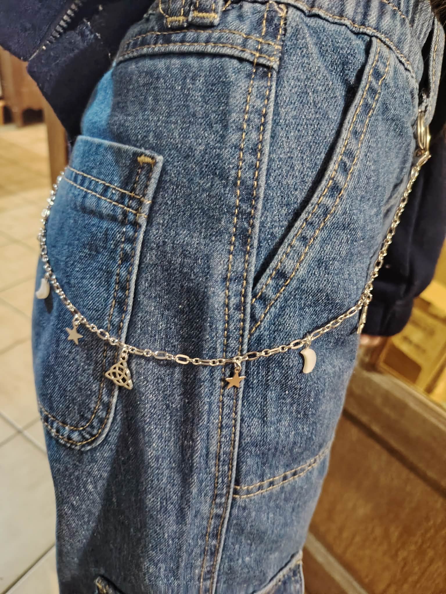 Chaîne de pantalon personnalisable portée sur jean bleu, avec breloques lune et étoile, accessoire mode tendance Magic Gaïa