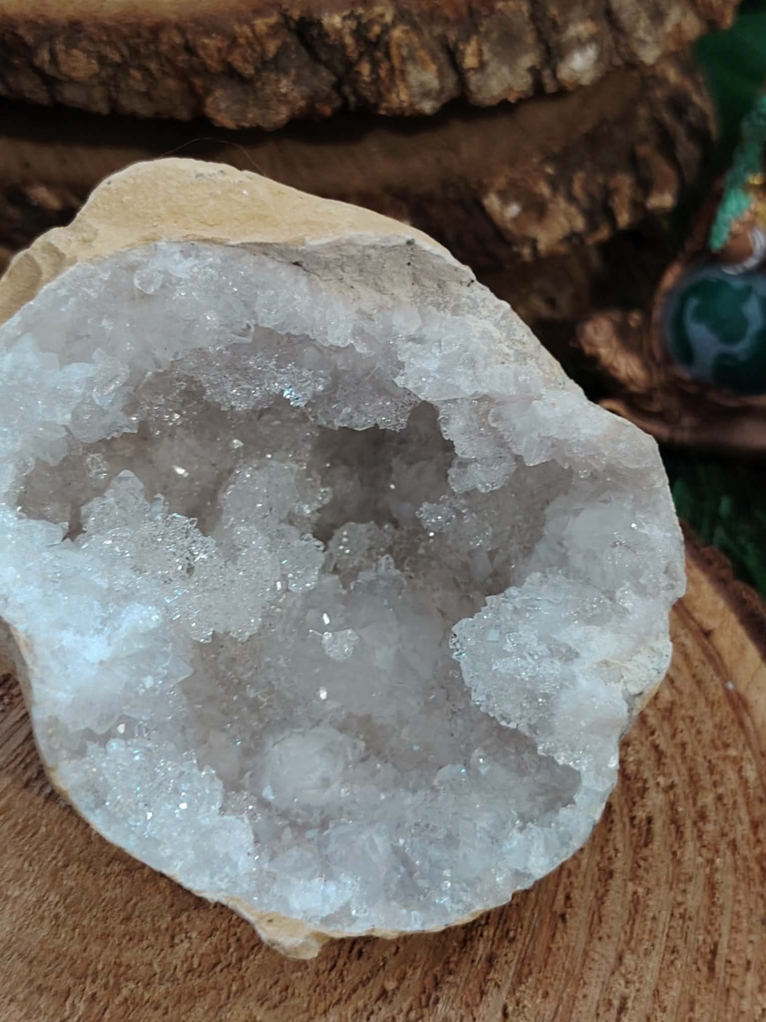 géode quartz blanc sur plateau bois avec papillon lithothérapie purification des pierres rechargement énergétique apaisement et énergie positive