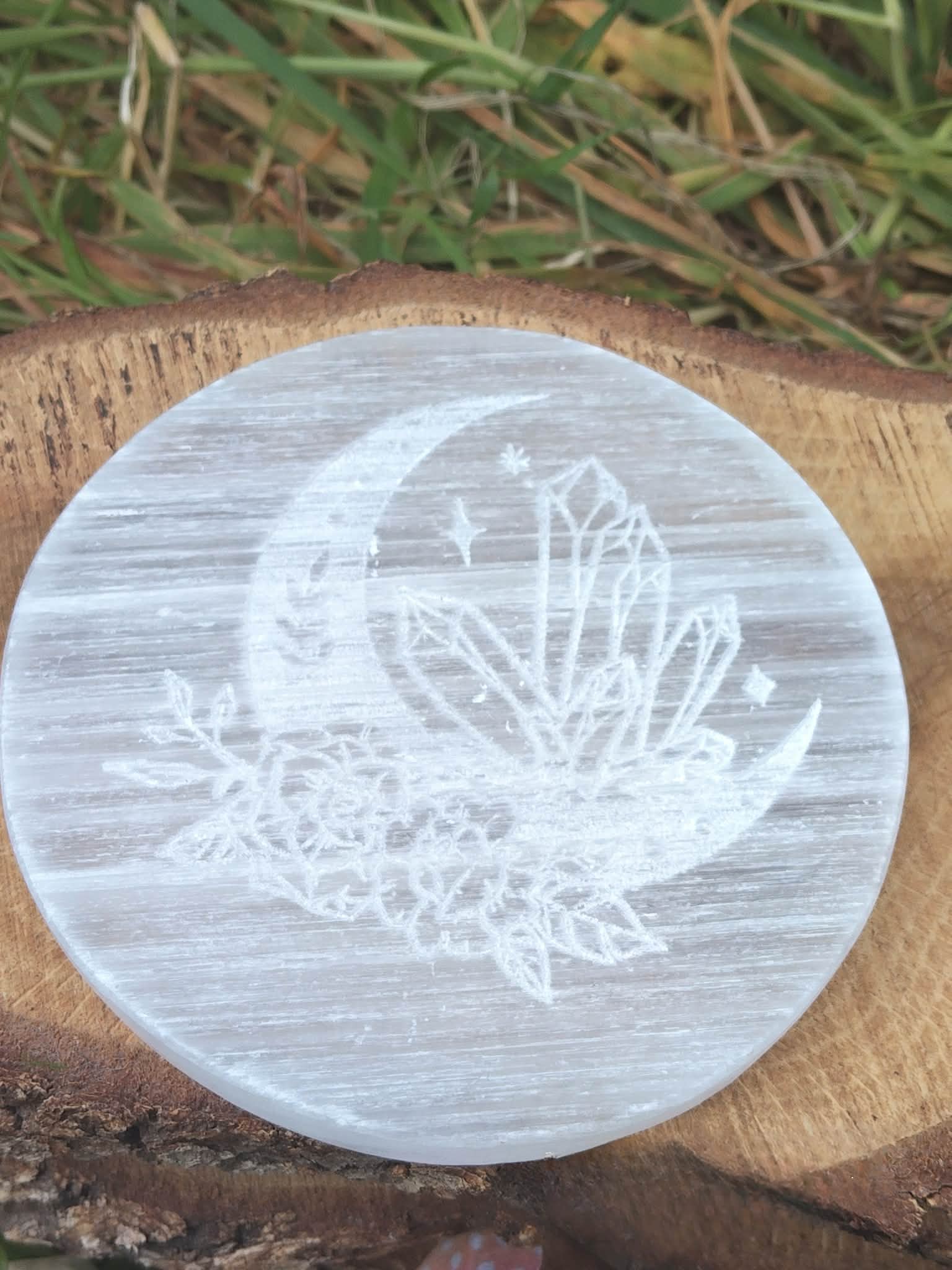 Support de rechargement en sélénite motif lunaire, posé sur rondin de bois, pour nettoyer l’énergie des cristaux et créer une ambiance zen