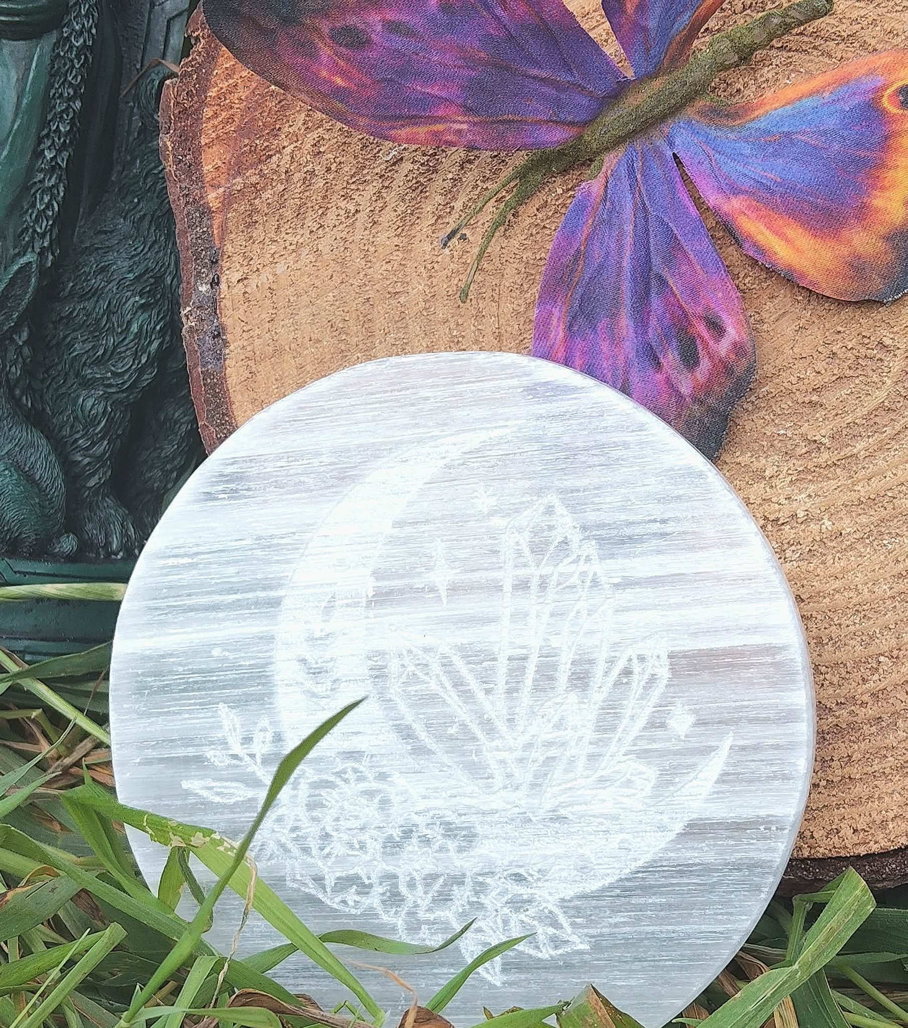 Plateau lune en sélénite posé dans l’herbe, décor papillon coloré, pour purifier les pierres et apporter paix intérieure