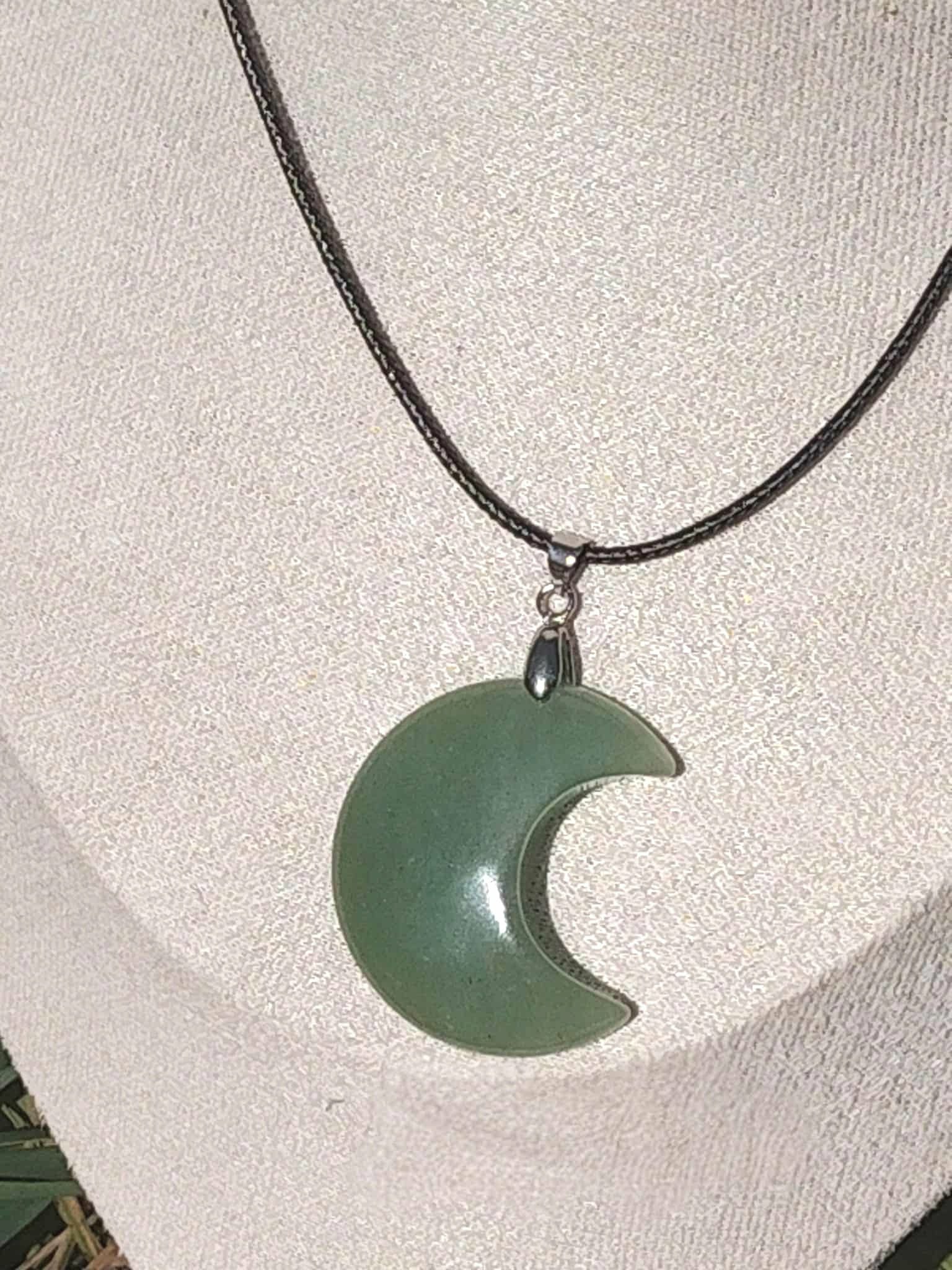 Pendentif lune en aventurine verte porté sur présentoir, bijou en pierre naturelle relié à l’harmonie du cœur, à la sérénité et à la douceur émotionnelle.