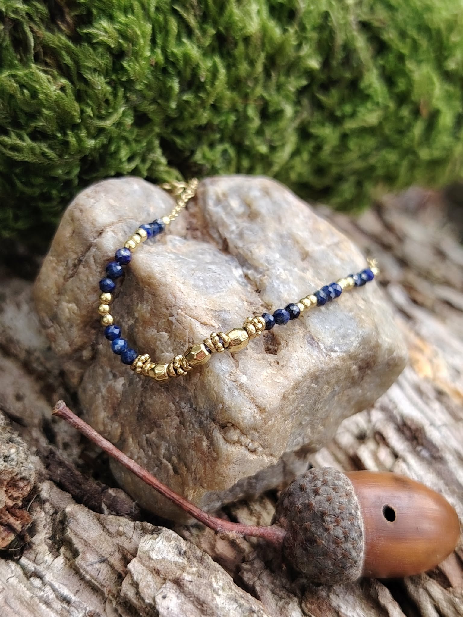 Bracelet chaîne fine doré en acier inoxydable avec perles de lapis-lazuli, photo en extérieur en Bretagne