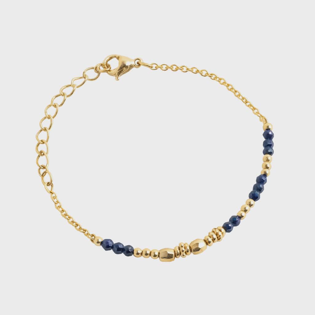 Bracelet chaîne fine doré en acier inoxydable avec perles de lapis-lazuli sur fond blanc