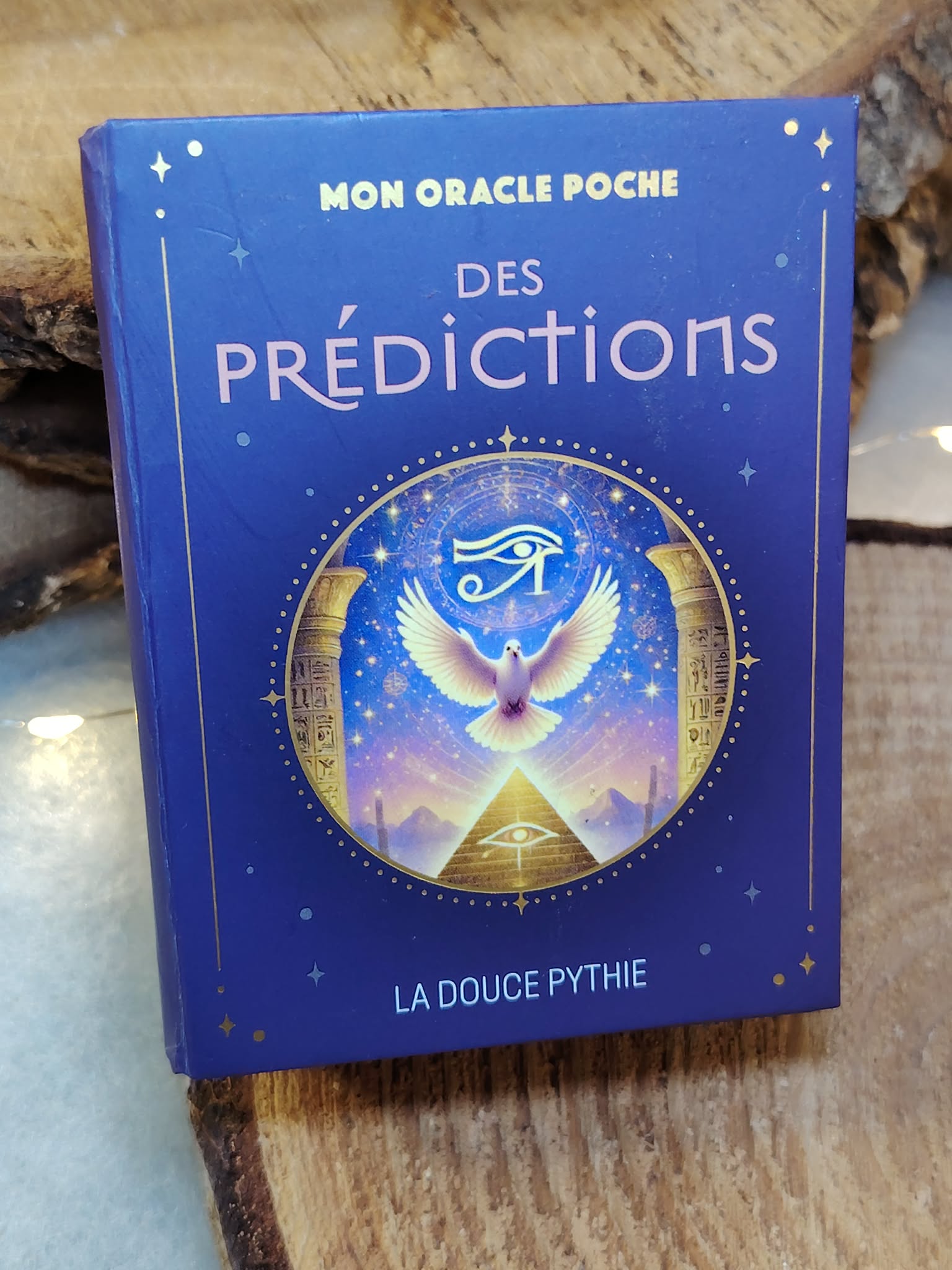 oracle poche des prédictions la douce pythie – jeu de cartes divinatoires – posé sur tronc de bois brut